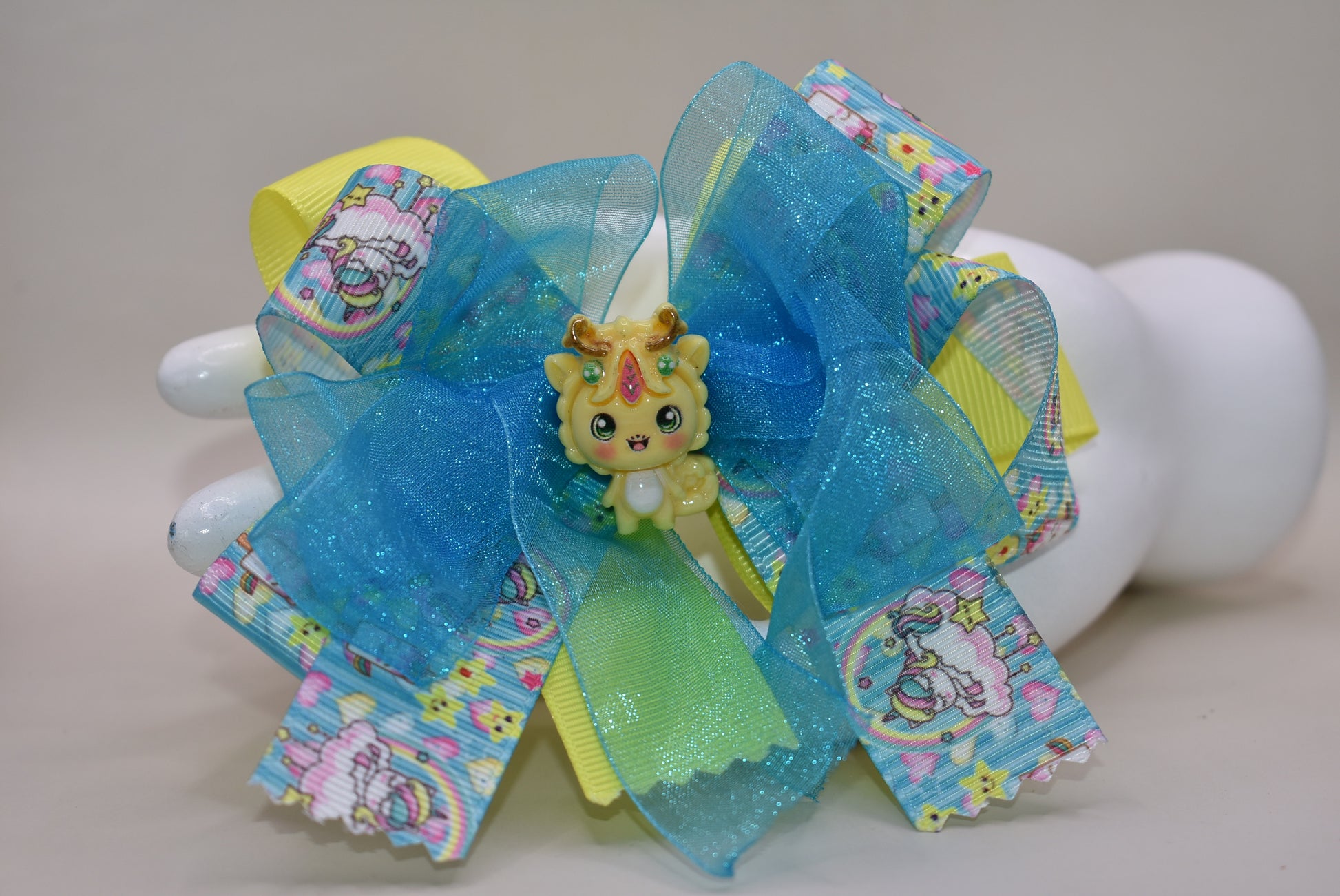 ✨ Get ready to add some magical flair to your hair! This one-of-a-kind unicorn bow features layers upon layers of gorgeous ribbon, beautifully accented with enchanting unicorn-themed ribbon and the sweetest little unicorn charms perched right on top. 🦄 The wrapped alligator clip makes it super easy to secure and wear all day long. Perfect for unicorn lovers who want to sprinkle a little extra sparkle into their style! 💫