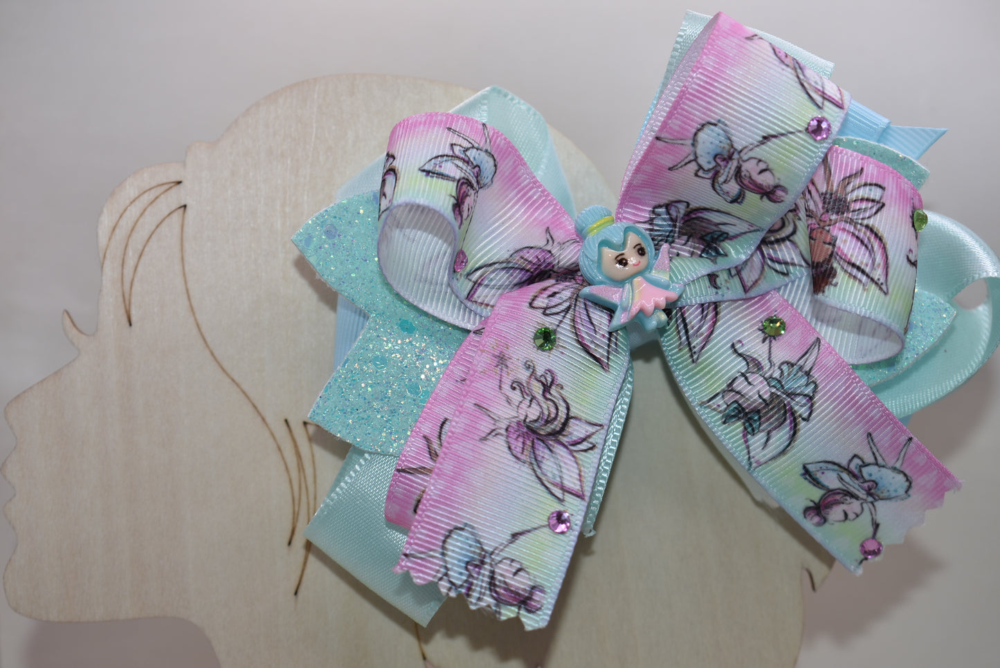 ✨ Get ready to sprinkle some magic into your day with this enchanting fairy-themed bow! Layered ribbons create gorgeous dimension, while shimmering faux leather adds extra sparkle that catches the light beautifully. Tiny gems and an adorable fairy charm bring whimsical fun to every hairstyle. The wrapped alligator clip keeps everything secure and comfortable for all-day wear. Perfect for adding a touch of fairy-tale charm to any look! 🧚♀️💎