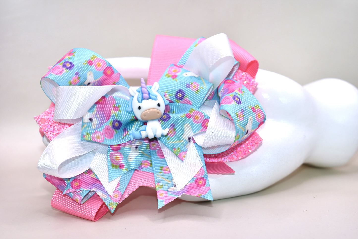 ✨ This adorable unicorn bow is a dreamy mix of soft pink and blue ribbons layered to perfection, featuring a special unicorn-themed ribbon that brings extra magic to the design. A precious little unicorn charm perches right on top, adding that extra touch of cuteness! 🦄 The wrapped alligator clip makes it super easy to wear all day long without any fuss. Perfect for adding a sprinkle of whimsy to any hairstyle! 💕🎀