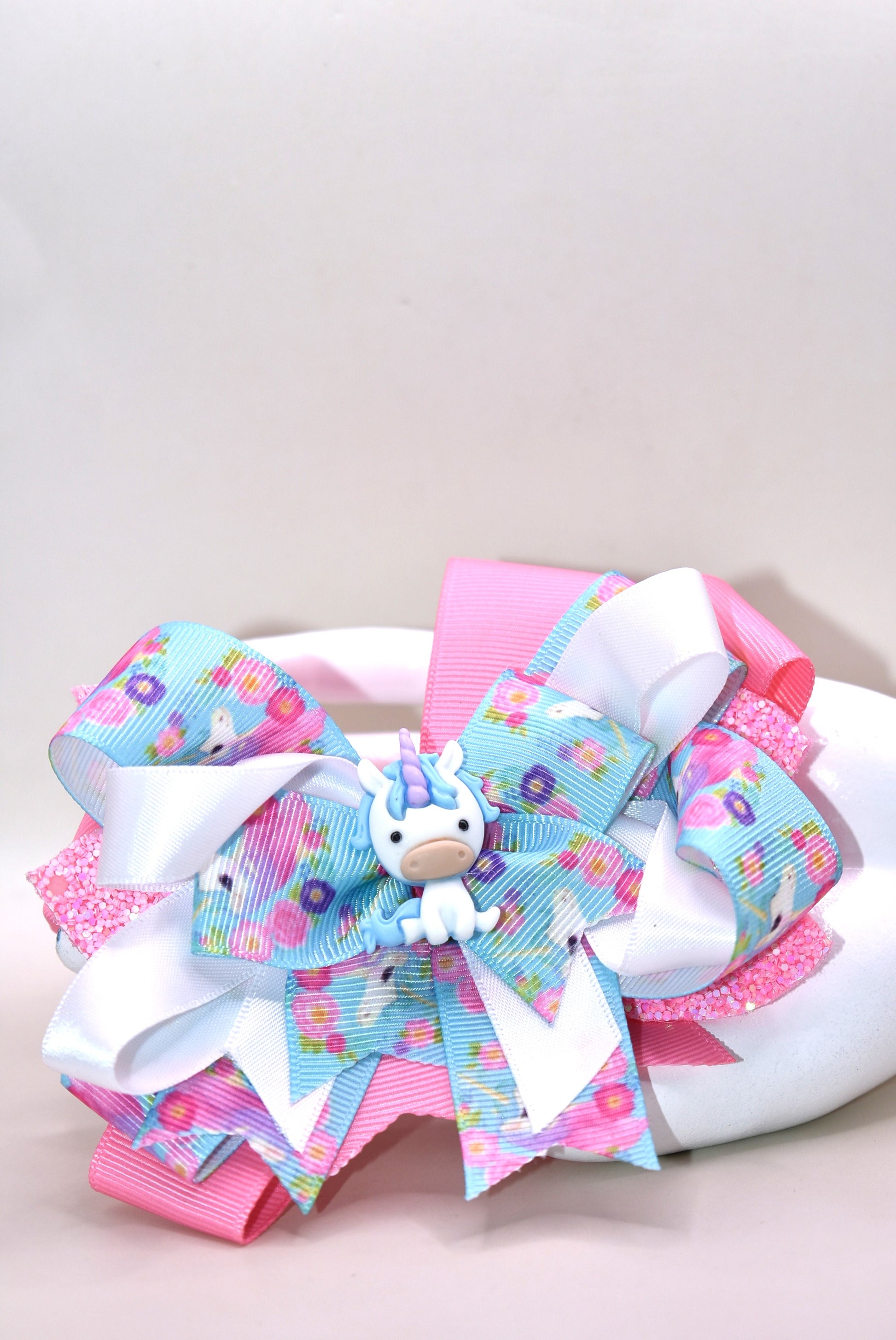 ✨ This adorable unicorn bow is a dreamy mix of soft pink and blue ribbons layered to perfection, featuring a special unicorn-themed ribbon that brings extra magic to the design. A precious little unicorn charm perches right on top, adding that extra touch of cuteness! 🦄 The wrapped alligator clip makes it super easy to wear all day long without any fuss. Perfect for adding a sprinkle of whimsy to any hairstyle! 💕🎀