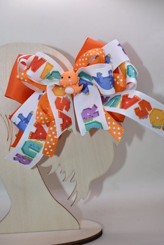 Meet your new favorite hair accessory! 🦕✨ This adorable orange dinosaur perches happily atop layers of vibrant ribbon, bringing instant joy to any hairstyle. The playful design features a wrapped alligator clip that's super easy to use—just clip and go! Perfect for adding a pop of personality and cuteness to your day. Whether you're heading to school, a playdate, or just want to smile a little brighter, this charming dino bow is ready to make your look roar with fun! 🎀😊