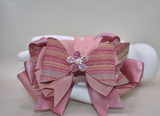 ✨ Introducing a dazzling accessory that brings instant glamour to any hairstyle! This beauty features shimmering glitter faux leather blended with luxe satin and grosgrain ribbon for a multi-textured look that catches the light beautifully. 💎 Topped with an adorable sparkly flower and delicate pearl detail, it's the perfect finishing touch for special occasions or everyday sparkle. The convenient wrapped alligator clip makes it effortless to secure and wear all day long. 🌸 Pure magic for your hair!