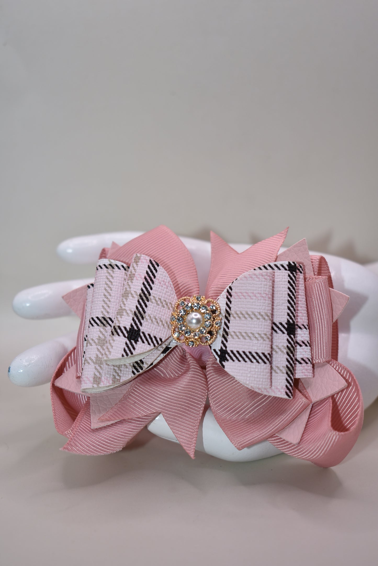 ✨ This charming bow brings instant elegance to any hairstyle! Featuring a gorgeous blush and black mixed plaid faux leather design with delicate ribbon layers underneath, it's topped with a sparkly gem and pearl charm for that extra touch of glamour. ✨ The secure alligator clip keeps it perfectly in place all day long. Whether you're dressing up for a special occasion or adding flair to your everyday look, this bow works beautifully for everyone—from the young at heart to the young at style! 🎀💕