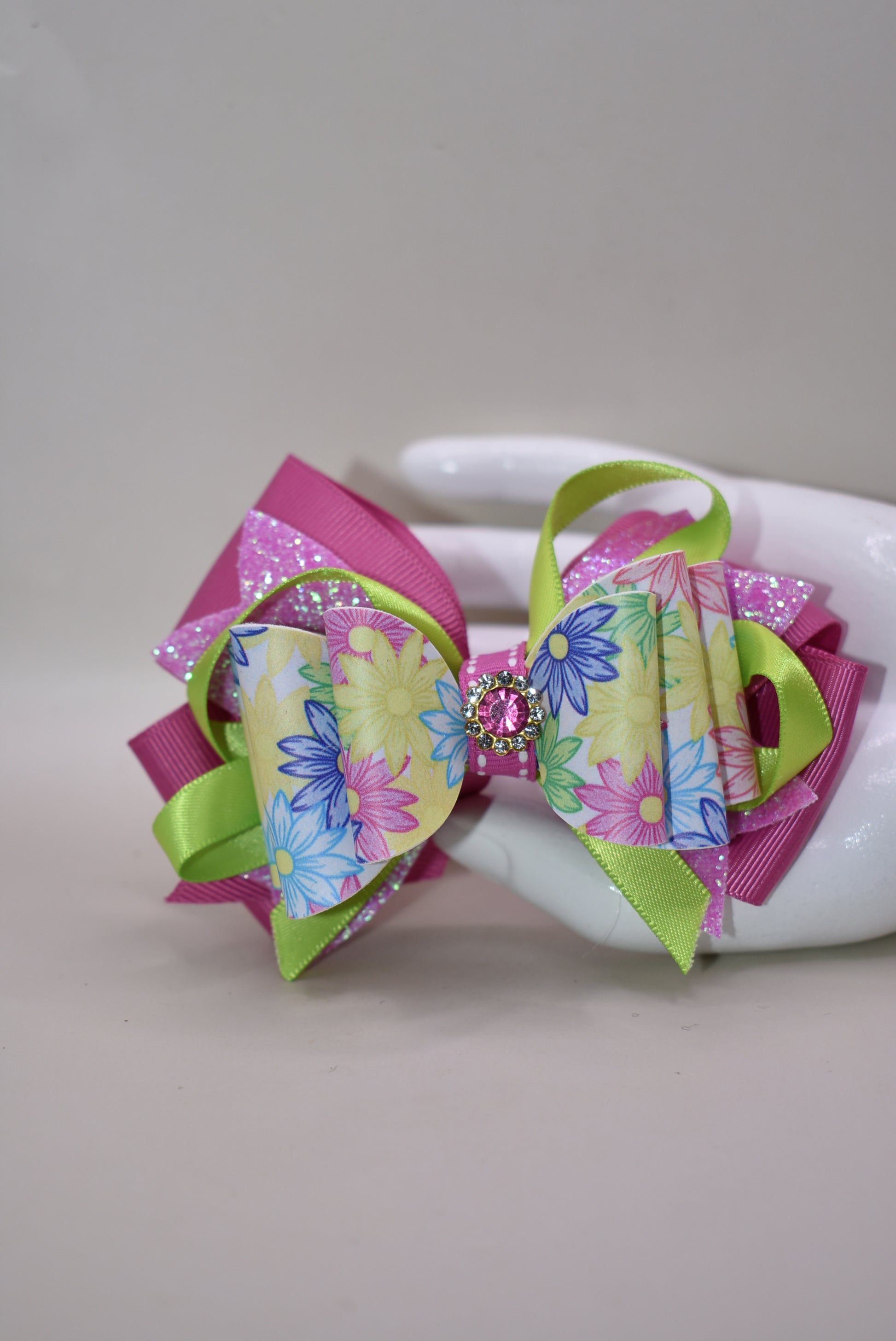 ✨ Get ready to turn heads with this absolutely gorgeous pink floral bow! 🌸 Featuring layers upon layers of silky ribbon for that full, fabulous look, this beauty is topped with a sparkling pink crystal charm that catches the light just right. 💎 The wrapped alligator clip on the back keeps everything secure and comfy all day long, so you can rock this charming accessory without a worry. Perfect for adding a touch of elegance and sparkle to any hairstyle! 🎀
