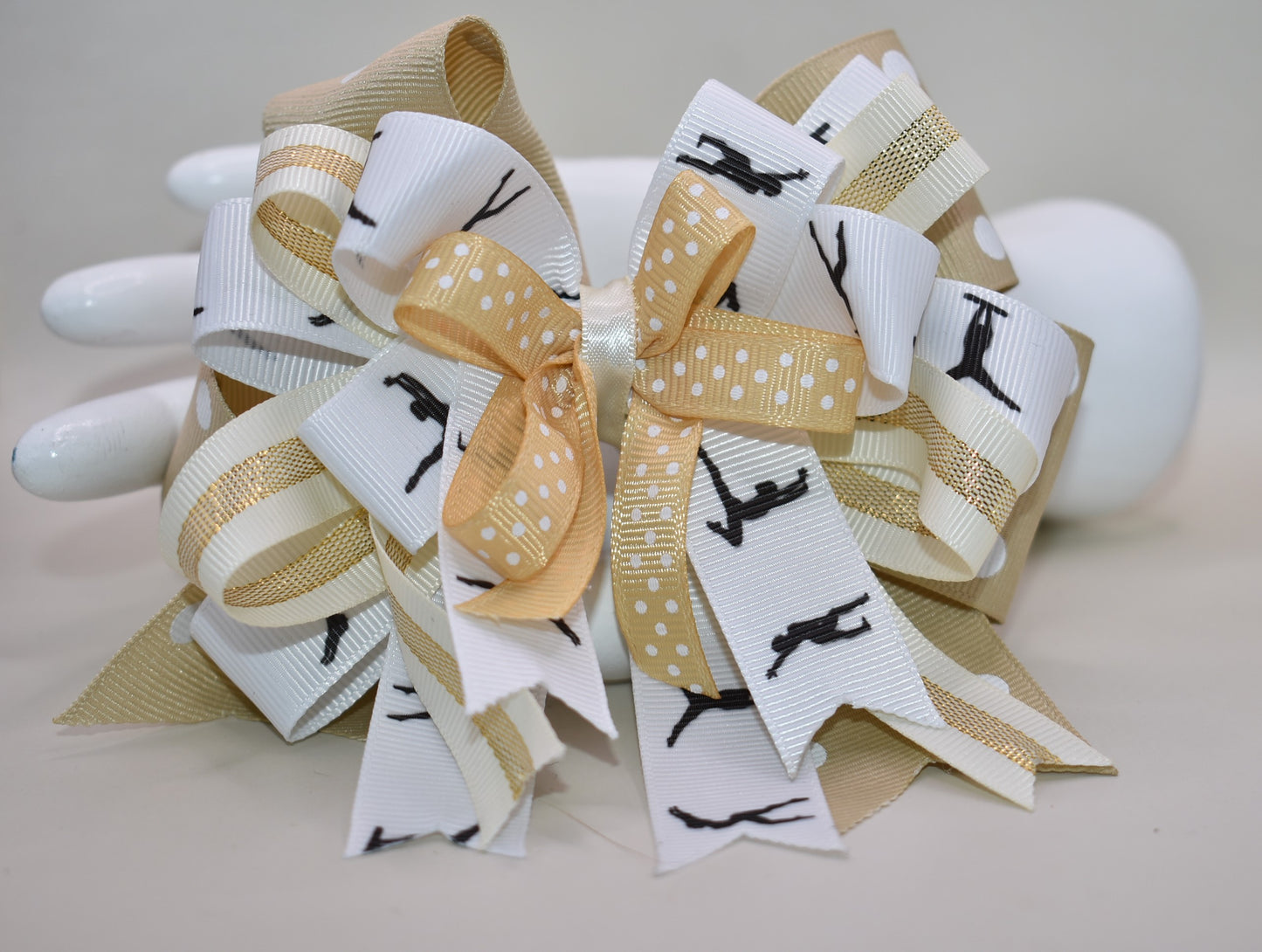 ✨ Let your little dancer shine with this gorgeous bow from Nana's Collection! Featuring luxurious layers of ribbon in soft cream, crisp white, and classic black, it's the perfect neutral accessory that pairs beautifully with any outfit. Whether she's heading to dance class, a special event, or just twirling around the house, this elegant bow adds that extra touch of charm and sophistication. 🎀 Watch her confidence bloom with every graceful move! 💕