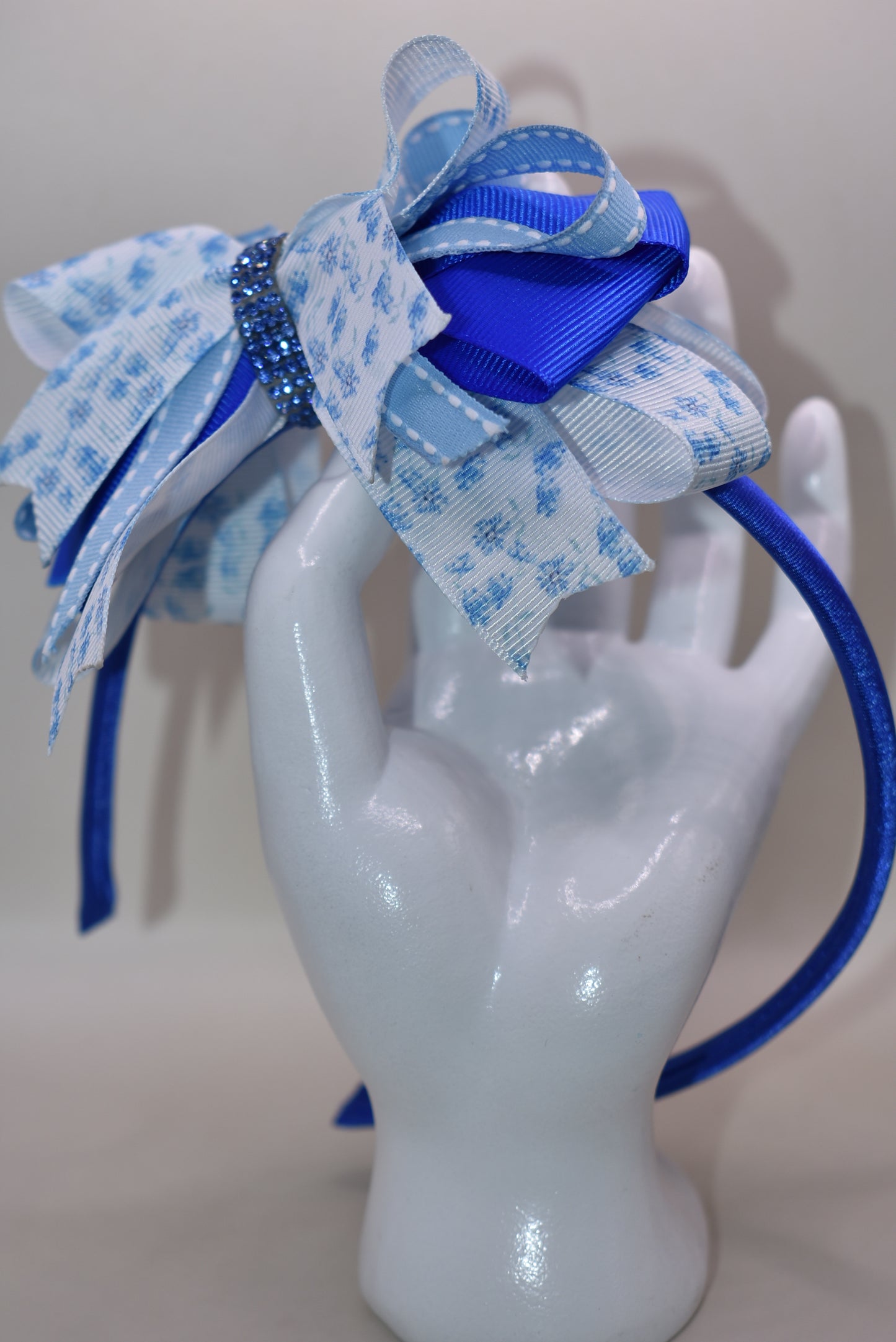 Slip on this gorgeous blue satin headband and let your hair stay put in style! 💙 Featuring delicate blue floral details and charming ribbon layers, it's the perfect accessory to elevate any look. Whether you're dressing up or keeping it casual, this comfortable headband keeps everything in place while adding that extra touch of elegance. ✨ A timeless piece that works with every outfit in your wardrobe! 🎀