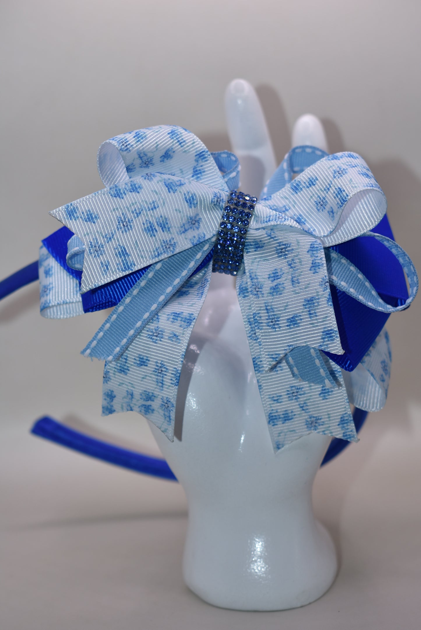 Slip on this gorgeous blue satin headband and let your hair stay put in style! 💙 Featuring delicate blue floral details and charming ribbon layers, it's the perfect accessory to elevate any look. Whether you're dressing up or keeping it casual, this comfortable headband keeps everything in place while adding that extra touch of elegance. ✨ A timeless piece that works with every outfit in your wardrobe! 🎀