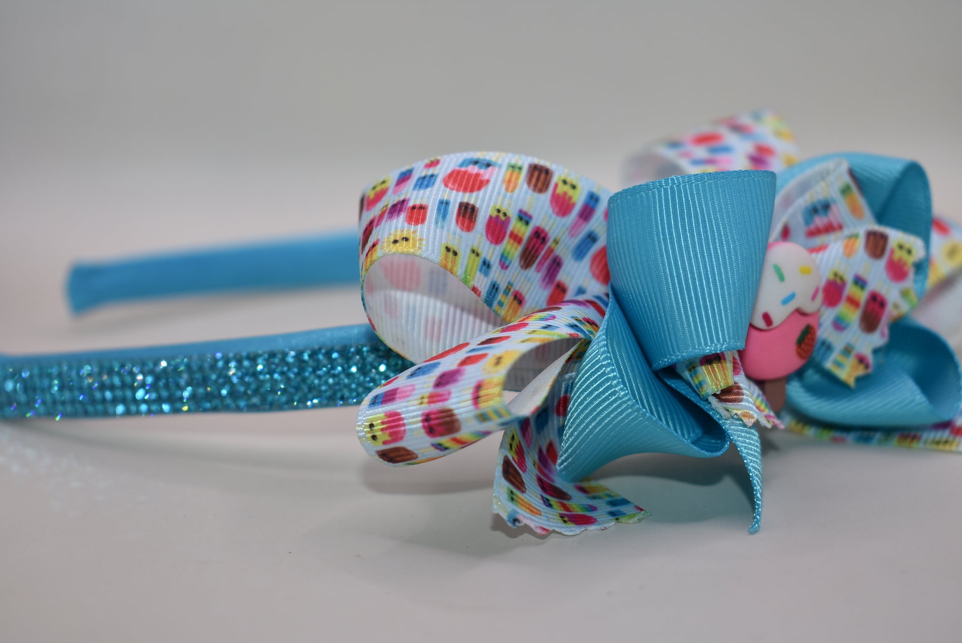 Wrap your hair in sweetness with this delightful satin headband! 🎀 Featuring a soft, flexible design that stays comfortable all day long, this charming piece showcases a playful ice cream cone charm perched on top and a bow adorned with layers of fun, glittery ribbon. 🍦✨ Perfect for ice cream lovers and fashion enthusiasts alike, it's the ideal accessory to add a whimsical touch to any outfit. Whether you're heading out for a treat or just want to spread some joy, this headband brings instant personality 