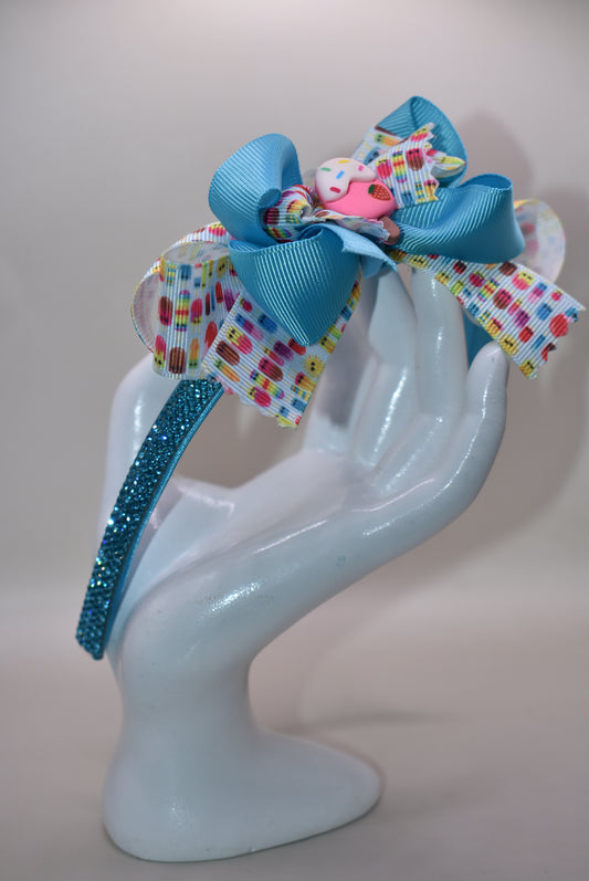 Wrap your hair in sweetness with this delightful satin headband! 🎀 Featuring a soft, flexible design that stays comfortable all day long, this charming piece showcases a playful ice cream cone charm perched on top and a bow adorned with layers of fun, glittery ribbon. 🍦✨ Perfect for ice cream lovers and fashion enthusiasts alike, it's the ideal accessory to add a whimsical touch to any outfit. Whether you're heading out for a treat or just want to spread some joy, this headband brings instant personality 