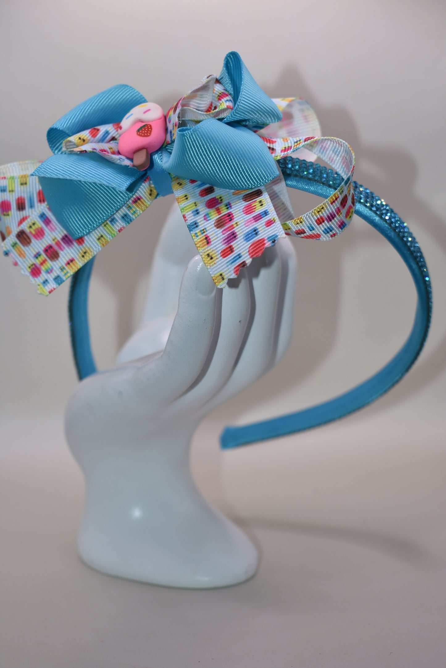 Wrap your hair in sweetness with this delightful satin headband! 🎀 Featuring a soft, flexible design that stays comfortable all day long, this charming piece showcases a playful ice cream cone charm perched on top and a bow adorned with layers of fun, glittery ribbon. 🍦✨ Perfect for ice cream lovers and fashion enthusiasts alike, it's the ideal accessory to add a whimsical touch to any outfit. Whether you're heading out for a treat or just want to spread some joy, this headband brings instant personality 