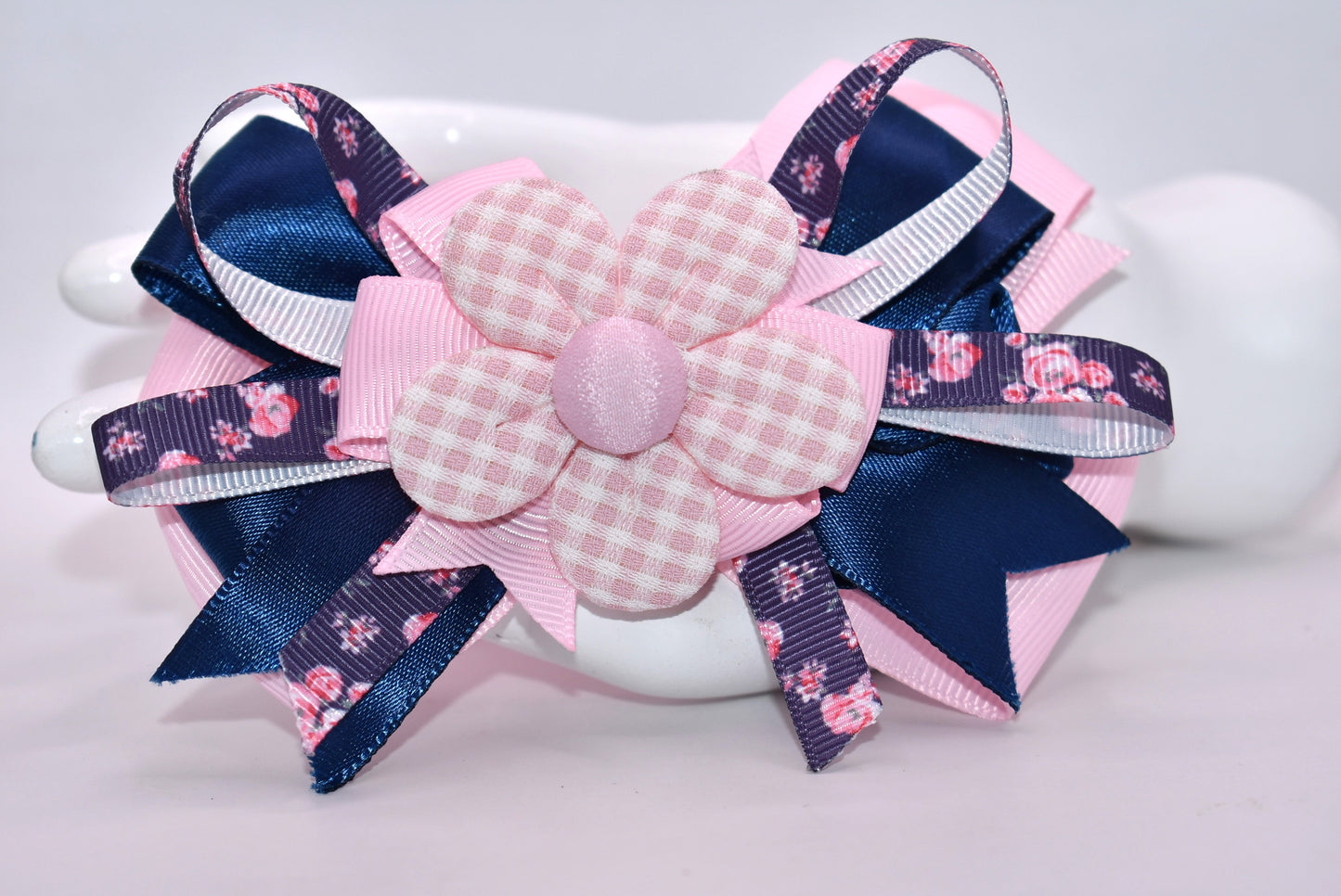 Get ready to spring into style with this one-of-a-kind bow! 🌸 Layers upon layers of gorgeous ribbon create dimension and movement, while an adorable checkered flower sits pretty on top for that perfect finishing touch. ✨ The wrapped alligator clip makes it effortless to wear—just clip and go! 🎀 This charming accessory is sure to have you falling head over heels. 💕