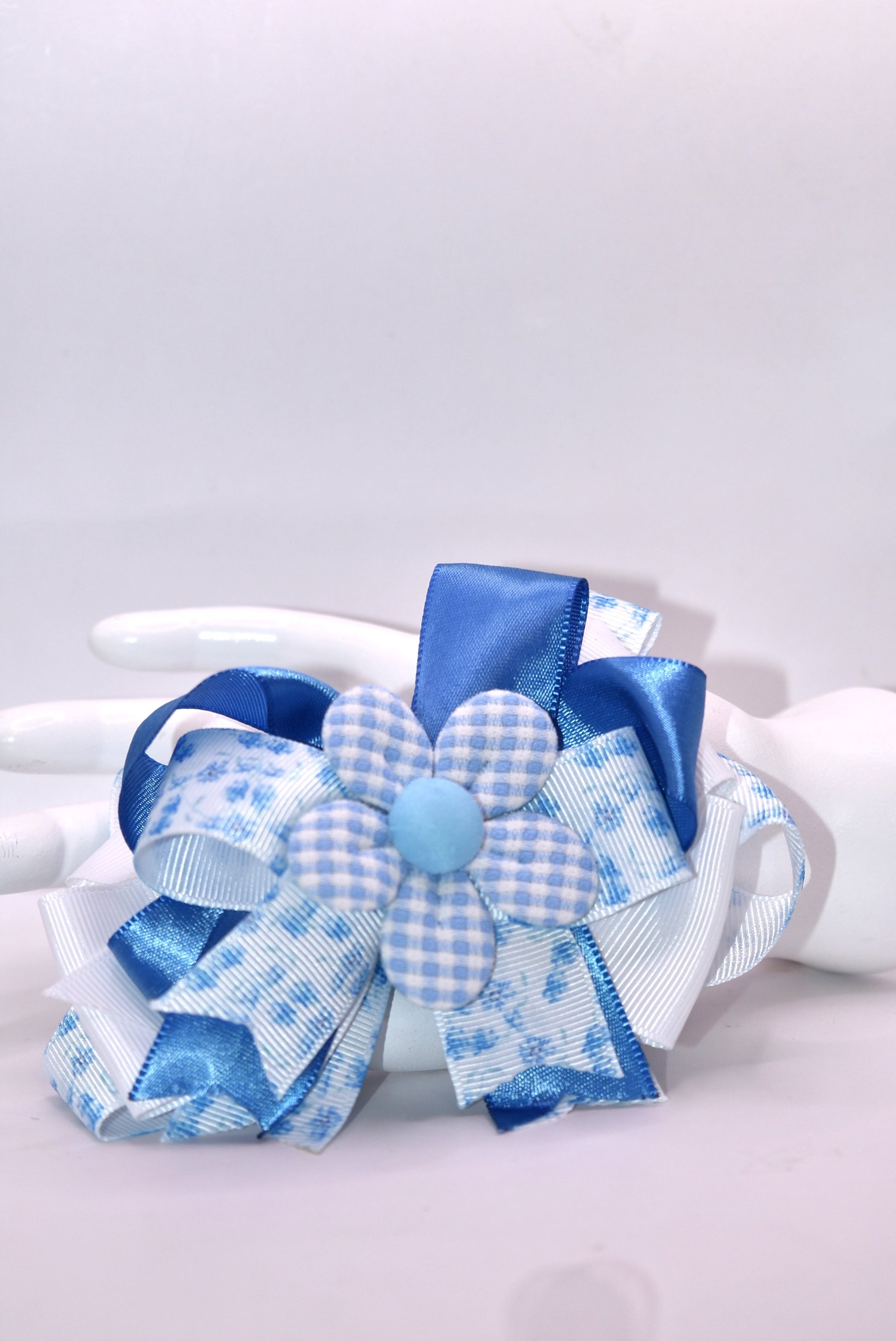 Welcome to spring with this charming blue bow! 🌸 This delightful accessory features a pretty blue floral ribbon beautifully mixed with coordinating blue and white ribbon, topped with an adorable checkered flower detail. 🎀 The wrapped alligator clip on the back makes it super easy to pop on and off whenever you need a fresh, springy touch. Perfect for adding a pop of color to any hairstyle! 💙✨
