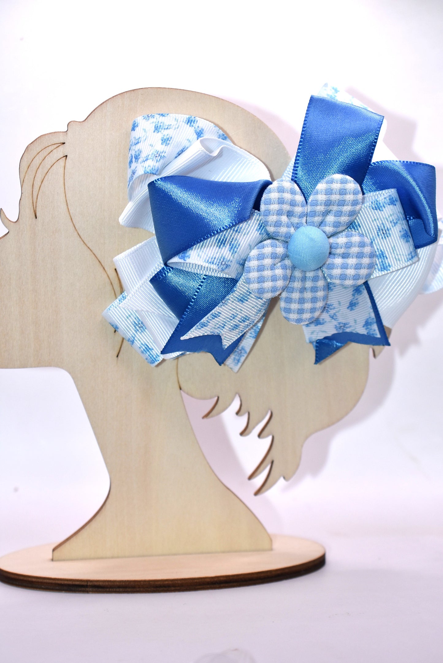 Welcome to spring with this charming blue bow! 🌸 This delightful accessory features a pretty blue floral ribbon beautifully mixed with coordinating blue and white ribbon, topped with an adorable checkered flower detail. 🎀 The wrapped alligator clip on the back makes it super easy to pop on and off whenever you need a fresh, springy touch. Perfect for adding a pop of color to any hairstyle! 💙✨