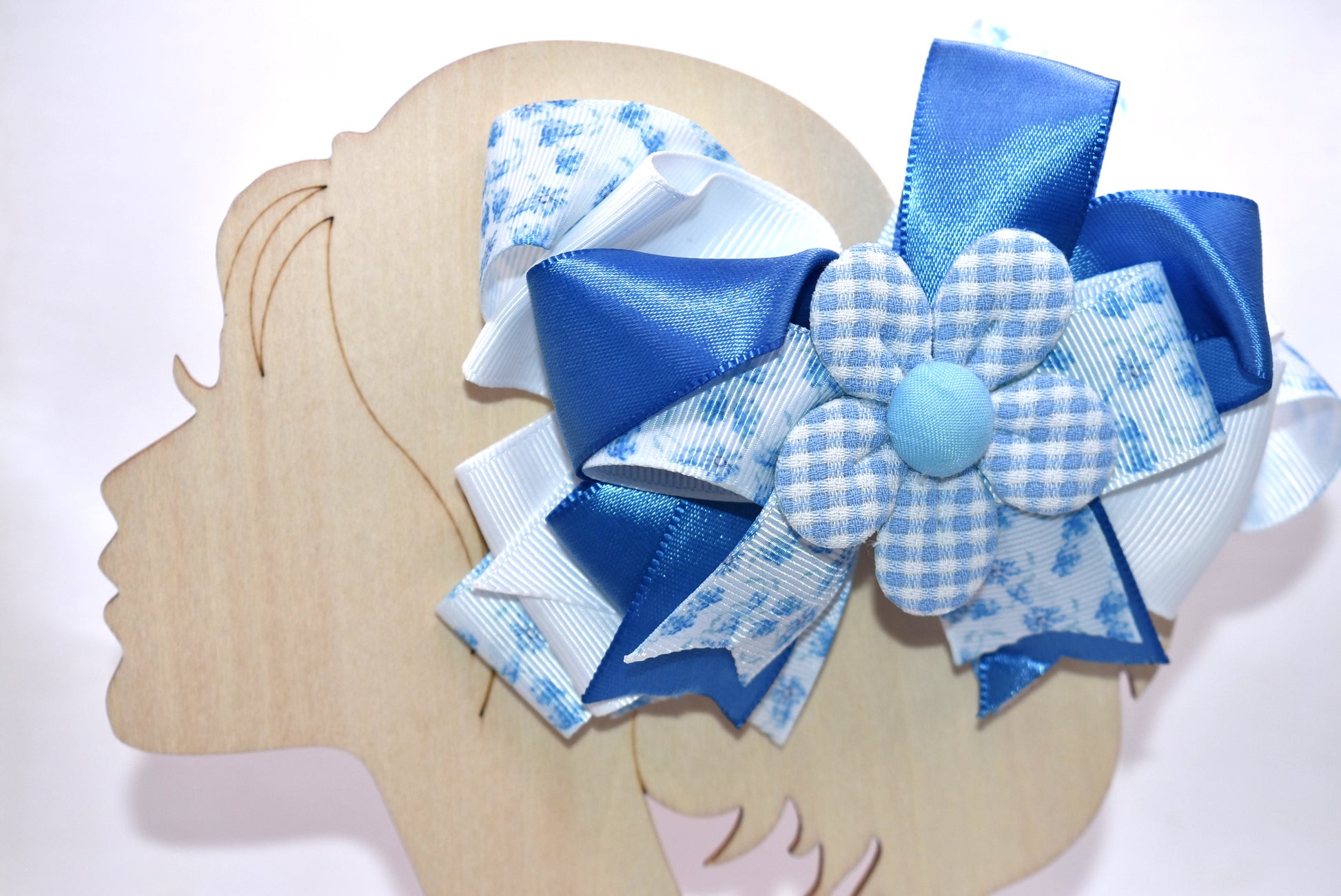 Welcome to spring with this charming blue bow! 🌸 This delightful accessory features a pretty blue floral ribbon beautifully mixed with coordinating blue and white ribbon, topped with an adorable checkered flower detail. 🎀 The wrapped alligator clip on the back makes it super easy to pop on and off whenever you need a fresh, springy touch. Perfect for adding a pop of color to any hairstyle! 💙✨
