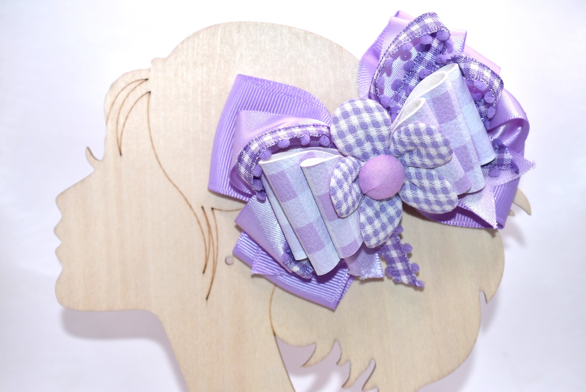 Introducing the perfect spring accessory! 🌸 This charming lavender flower bow features delicate layers of mixed ribbon materials that create beautiful dimension and texture. The back showcases a sweet checkered flower detail, while the secure alligator clip keeps your style in place all day long. 🎀 Whether you're dressing up for a special occasion or adding a pop of personality to your everyday look, this pretty bow brings that effortless, polished finish you've been searching for. ✨