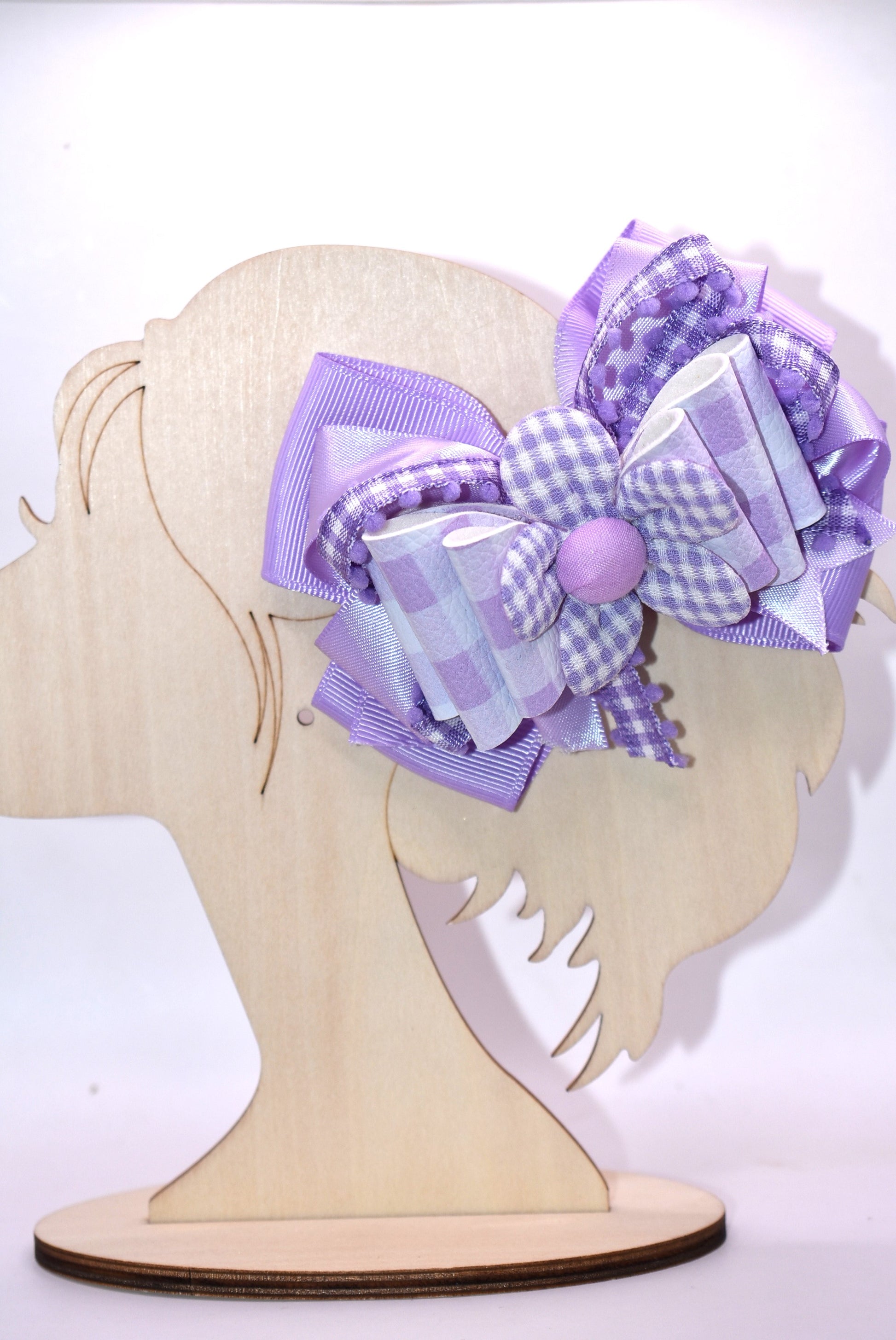 Introducing the perfect spring accessory! 🌸 This charming lavender flower bow features delicate layers of mixed ribbon materials that create beautiful dimension and texture. The back showcases a sweet checkered flower detail, while the secure alligator clip keeps your style in place all day long. 🎀 Whether you're dressing up for a special occasion or adding a pop of personality to your everyday look, this pretty bow brings that effortless, polished finish you've been searching for. ✨