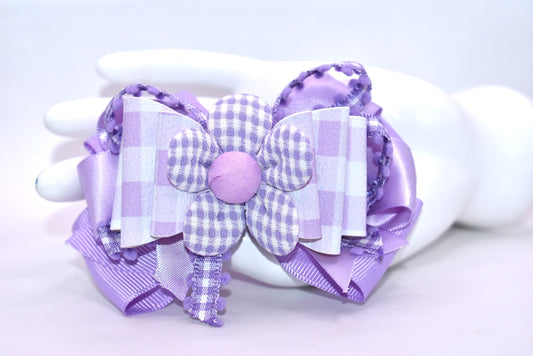 Introducing the perfect spring accessory! 🌸 This charming lavender flower bow features delicate layers of mixed ribbon materials that create beautiful dimension and texture. The back showcases a sweet checkered flower detail, while the secure alligator clip keeps your style in place all day long. 🎀 Whether you're dressing up for a special occasion or adding a pop of personality to your everyday look, this pretty bow brings that effortless, polished finish you've been searching for. ✨