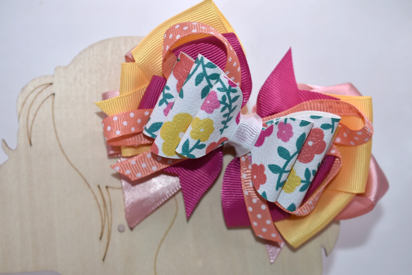 Get ready to turn heads with this adorable floral bow! 🌸 Bursting with pretty hues of orange, pink, and yellow, this charming accessory features delicate flowers, playful polka dots, and layers upon layers of ribbon for maximum cuteness. 🎀 The secure wrapped alligator clip keeps your style in place all day long. Perfect for adding a pop of color and personality to any look—you'll absolutely fall in love! 💕✨