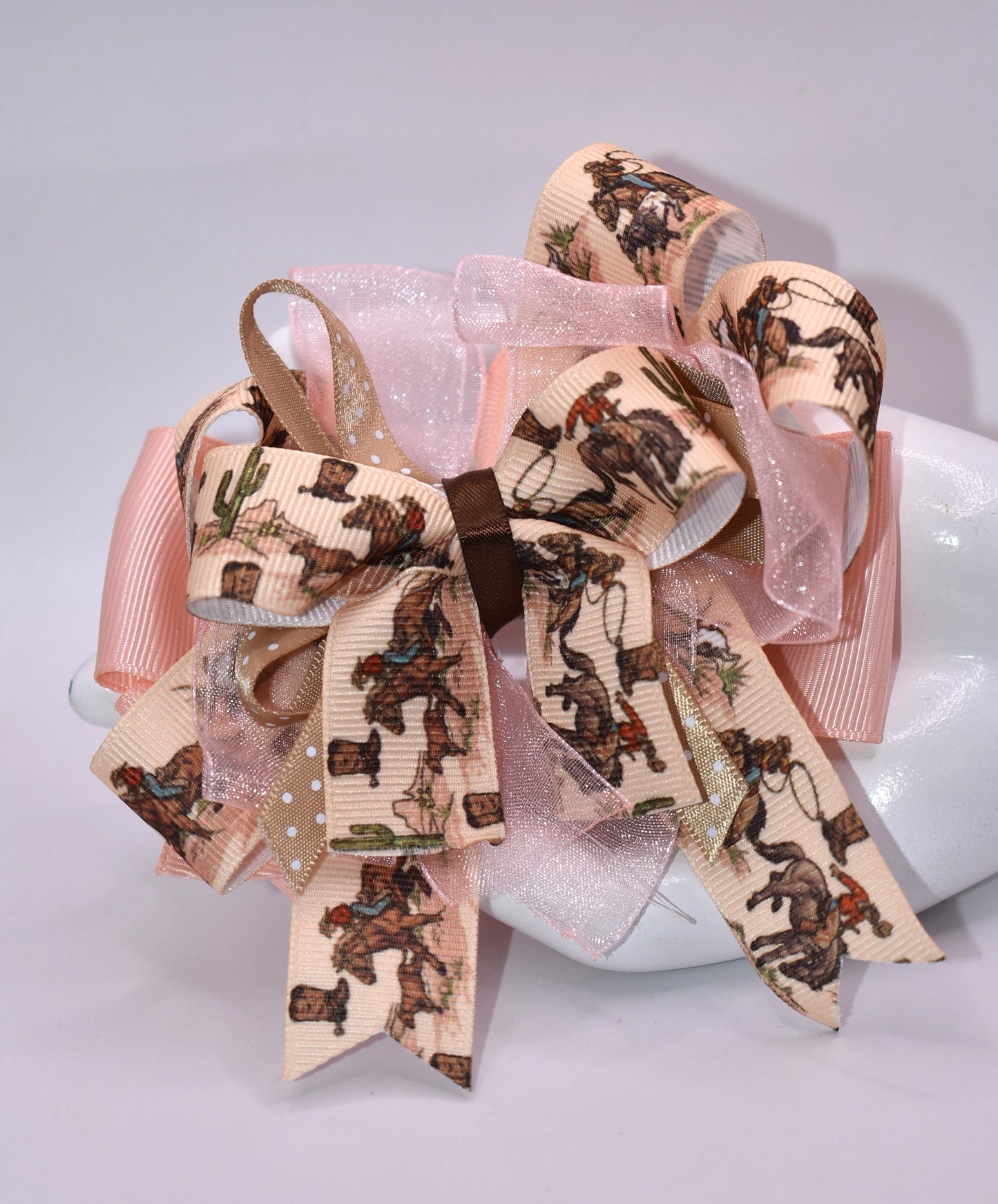 Saddle up for style with this adorable cowgirl bow! 🤠 Featuring a vibrant ribbon layer decorated with charming cowgirl motifs, this hair accessory brings Western flair to any look. The secure alligator clip backing keeps your hair in place all day long, whether you're heading to the rodeo or just channeling your inner cowgirl. 🎀 Perfect for adding a playful touch to braids, ponytails, or half-up styles. Yeehaw! 🌟