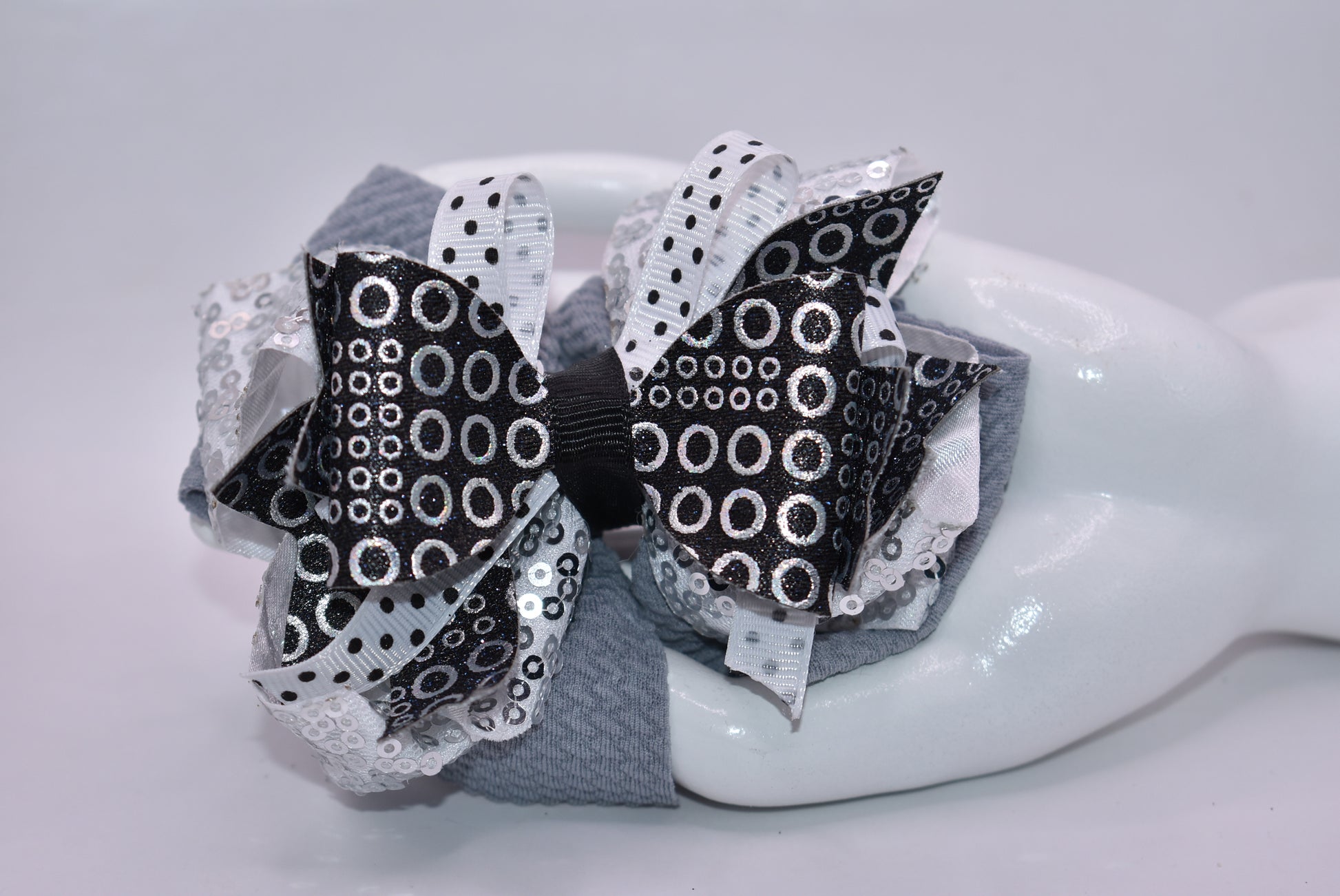 ✨ Stand out with Nana's Collection A4 – the bow that breaks the mold! 🎀 This stunning piece features a chic black, white, and silver palette that works together like magic. ✨ Packed with eye-catching shapes and sparkles that catch every light, it's the perfect accessory for anyone who dares to be different. 💫 The wrapped alligator clip slides on effortlessly, so you can rock this beauty all day long without a second thought. 🌟