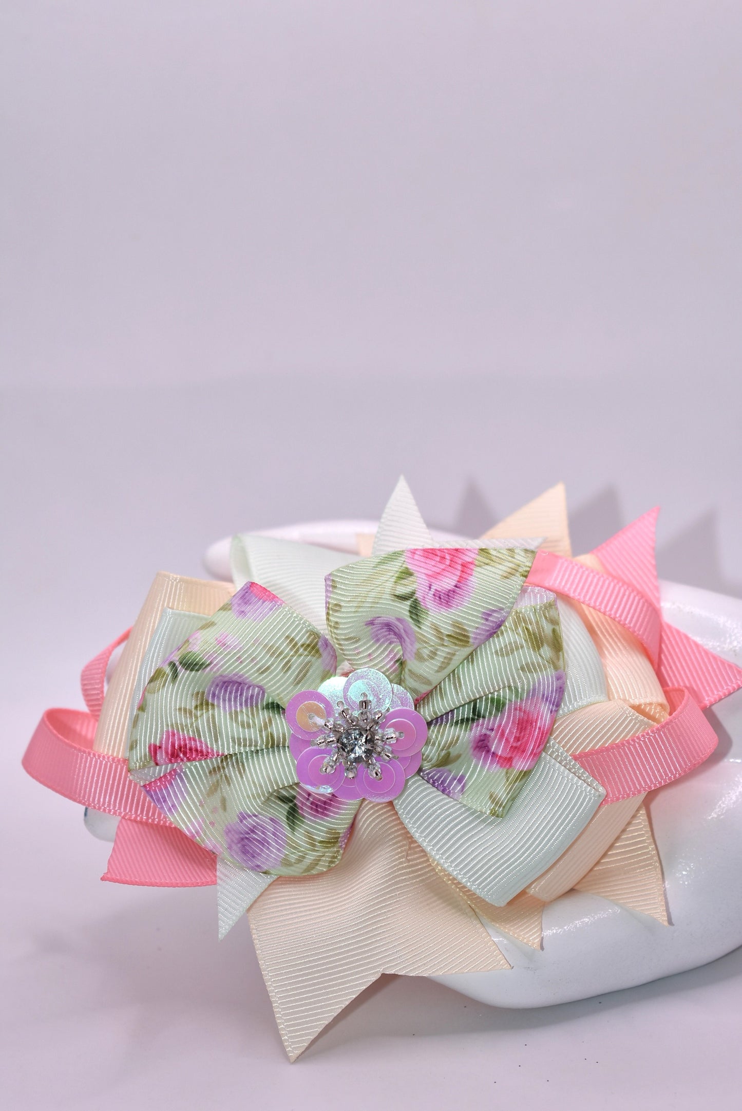This charming bow brings springtime magic to any hairstyle! 🌸 Soft pastel pink and green hues create a dreamy aesthetic, while an adorable floral design with a sparkling crystal arrow detail catches the light beautifully throughout the day. ✨ The convenient alligator clip makes it effortless to secure, perfect for adding a touch of whimsy to your look. 🎀 Ideal for anyone who loves sweet, feminine accessories with a playful twist! 💚💗