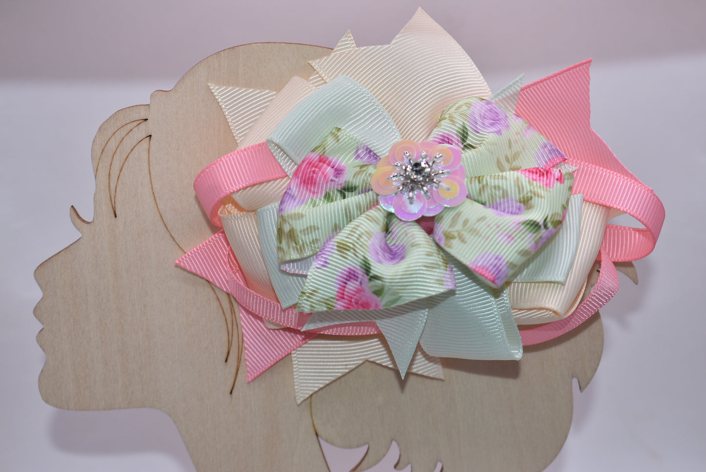 This charming bow brings springtime magic to any hairstyle! 🌸 Soft pastel pink and green hues create a dreamy aesthetic, while an adorable floral design with a sparkling crystal arrow detail catches the light beautifully throughout the day. ✨ The convenient alligator clip makes it effortless to secure, perfect for adding a touch of whimsy to your look. 🎀 Ideal for anyone who loves sweet, feminine accessories with a playful twist! 💚💗