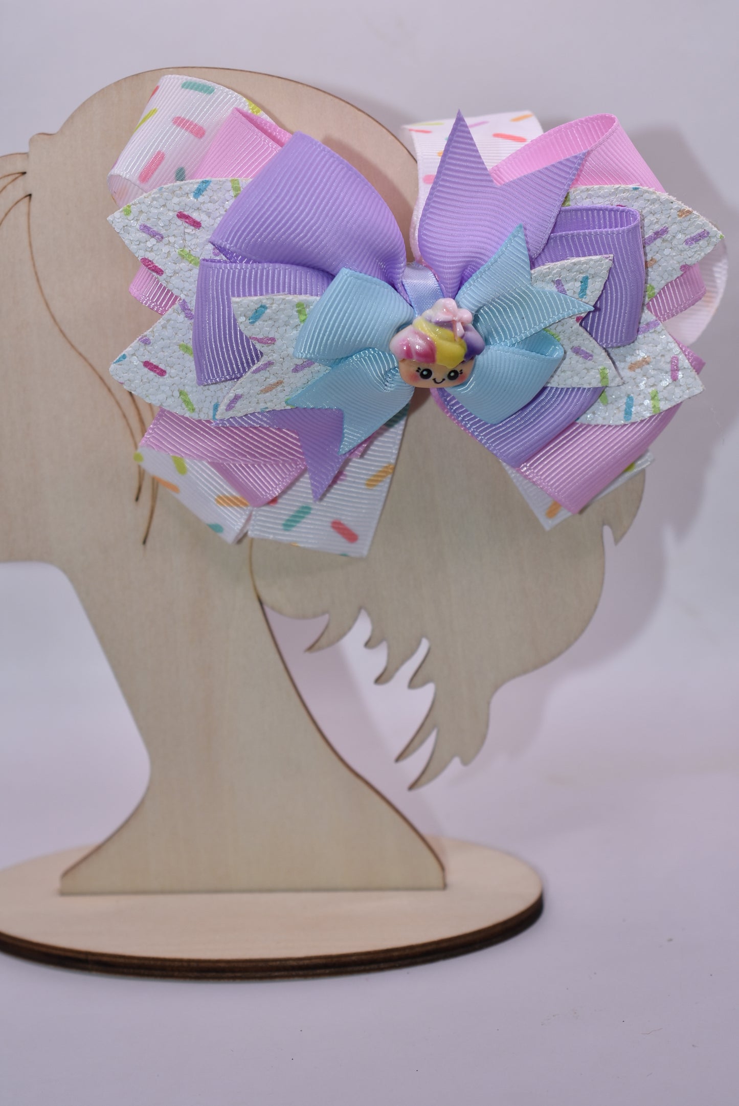 This adorably delicious sprinkle bow is pure cuteness! 🎀✨ Layered ribbon and faux leather create a textured, eye-catching design that's absolutely irresistible. A sweet little cupcake charm perches on top, adding the perfect finishing touch to this charming accessory. 🧁 The wrapped alligator clip on back ensures a secure, comfortable fit all day long. Perfect for adding a playful pop of personality to any hairstyle! 💕