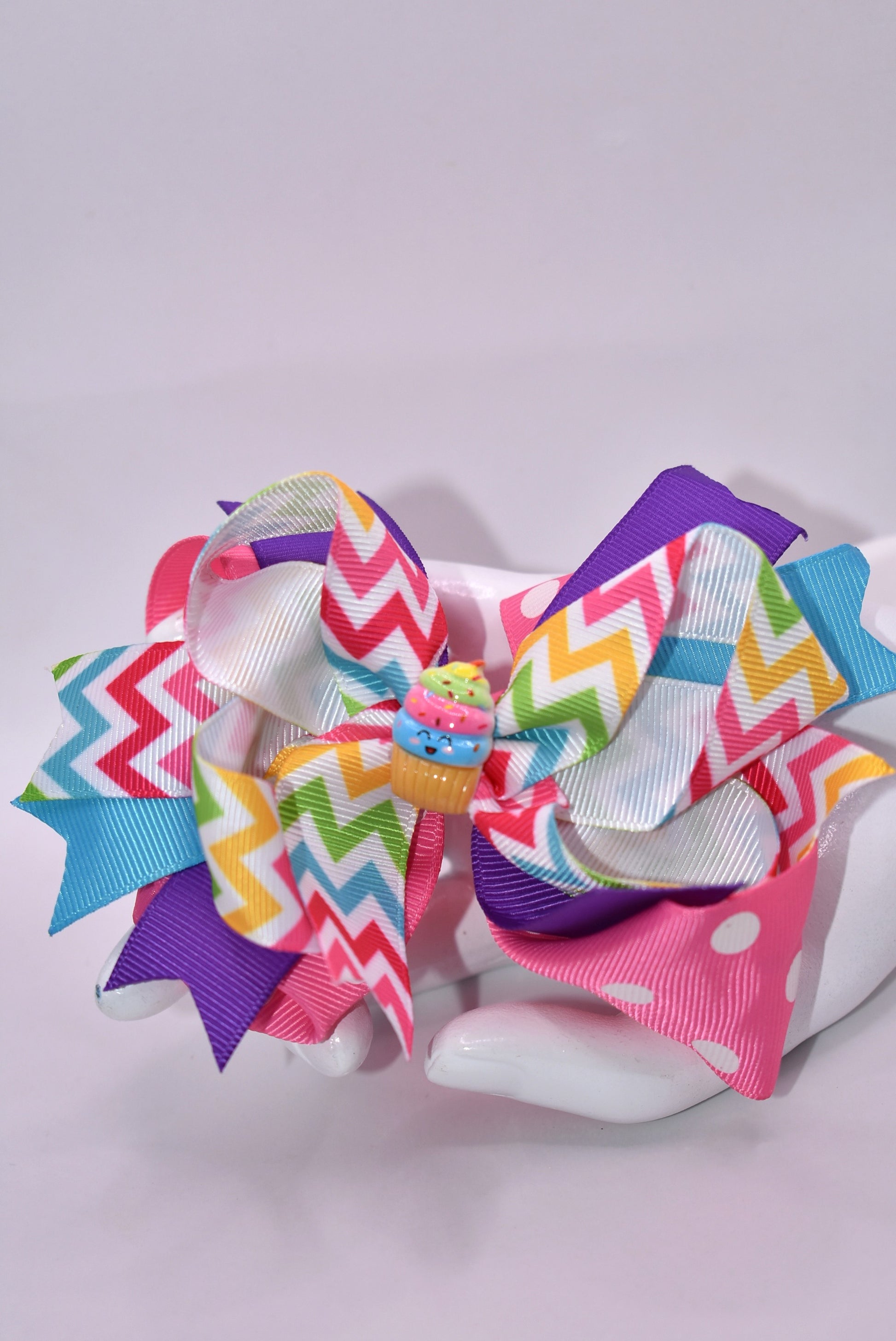 Sweeten your style with this delightful bow! 🎀✨ Featuring vibrant, layered bows adorned with ribbons in a rainbow of colors, this playful accessory brings instant charm to any look. A precious little cupcake charm perches on top, adding an extra touch of sugary sweetness. 🧁 The sturdy metal alligator clip makes styling effortless—just clip and go! Perfect for hair, bags, or anywhere you want to add a pop of fun and personality. 💕🌈