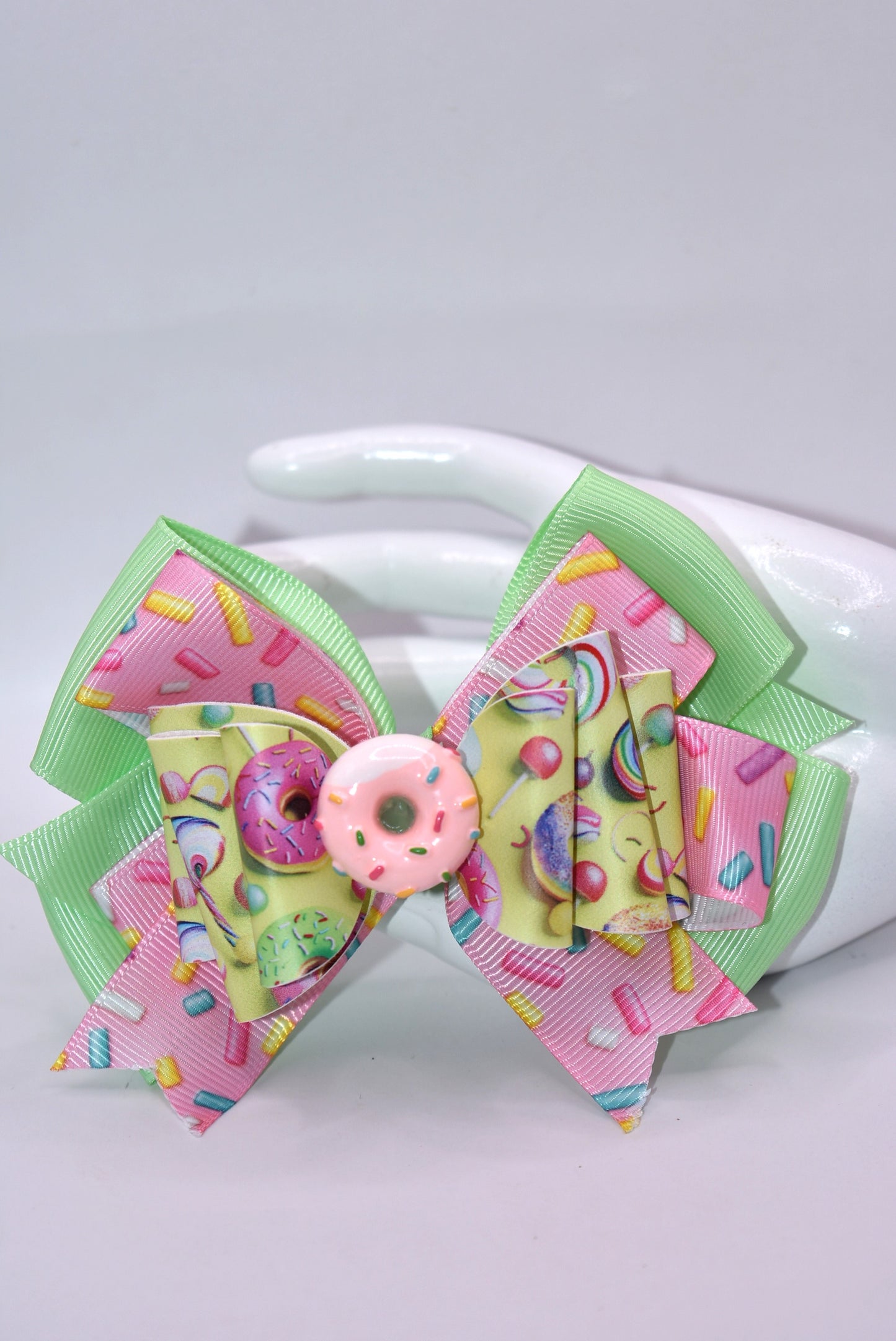 🍩 Calling all donut devotees! This adorable bow brings sweet style to your collection with its bright, cheerful design. Featuring layers of faux leather and ribbon adorned with a delightful donut motif, it's topped with the cutest pink sprinkle donut charm you've ever seen. Perfect for adding a pop of sugary sweetness to your accessories! 🎀✨