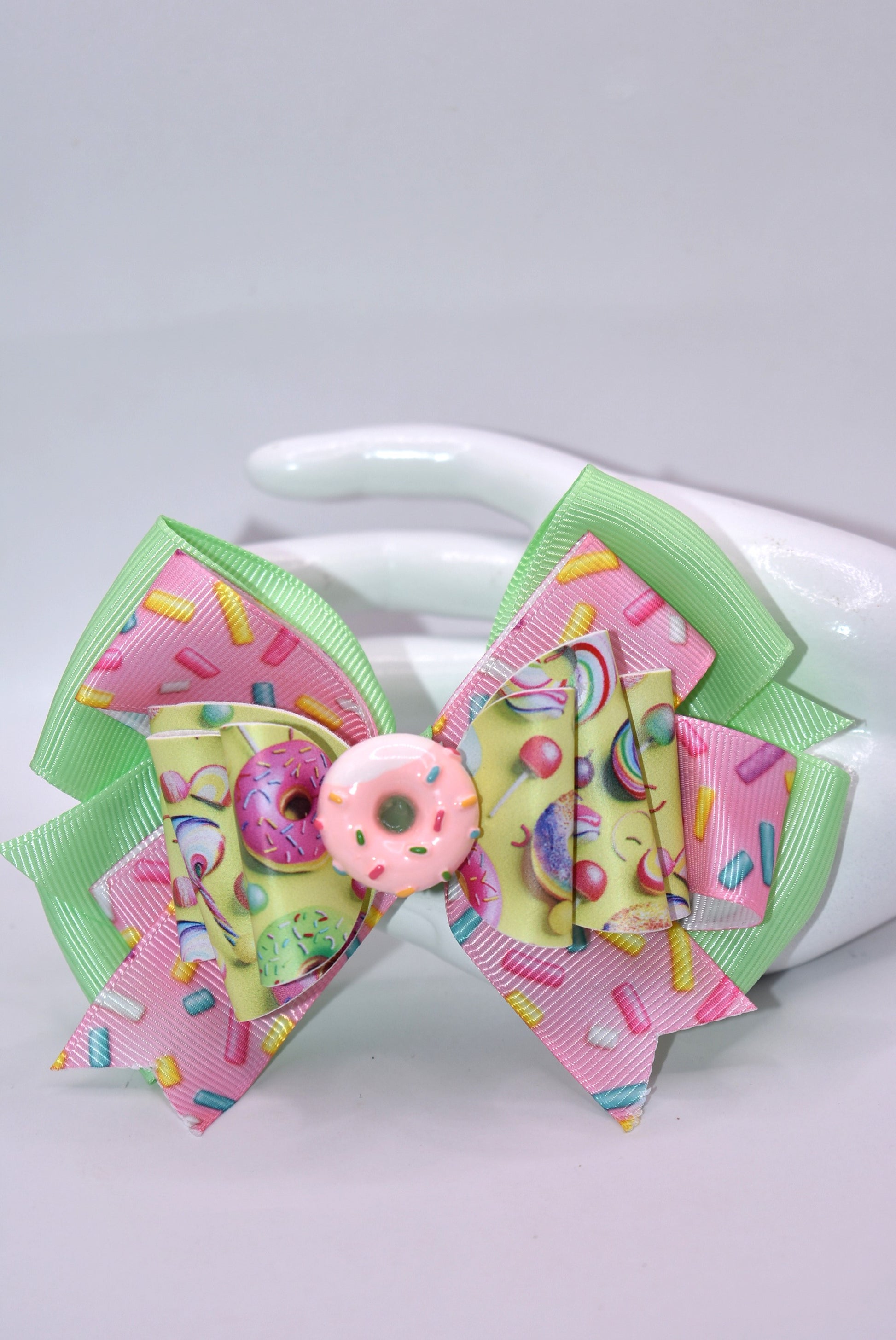 🍩 Calling all donut devotees! This adorable bow brings sweet style to your collection with its bright, cheerful design. Featuring layers of faux leather and ribbon adorned with a delightful donut motif, it's topped with the cutest pink sprinkle donut charm you've ever seen. Perfect for adding a pop of sugary sweetness to your accessories! 🎀✨