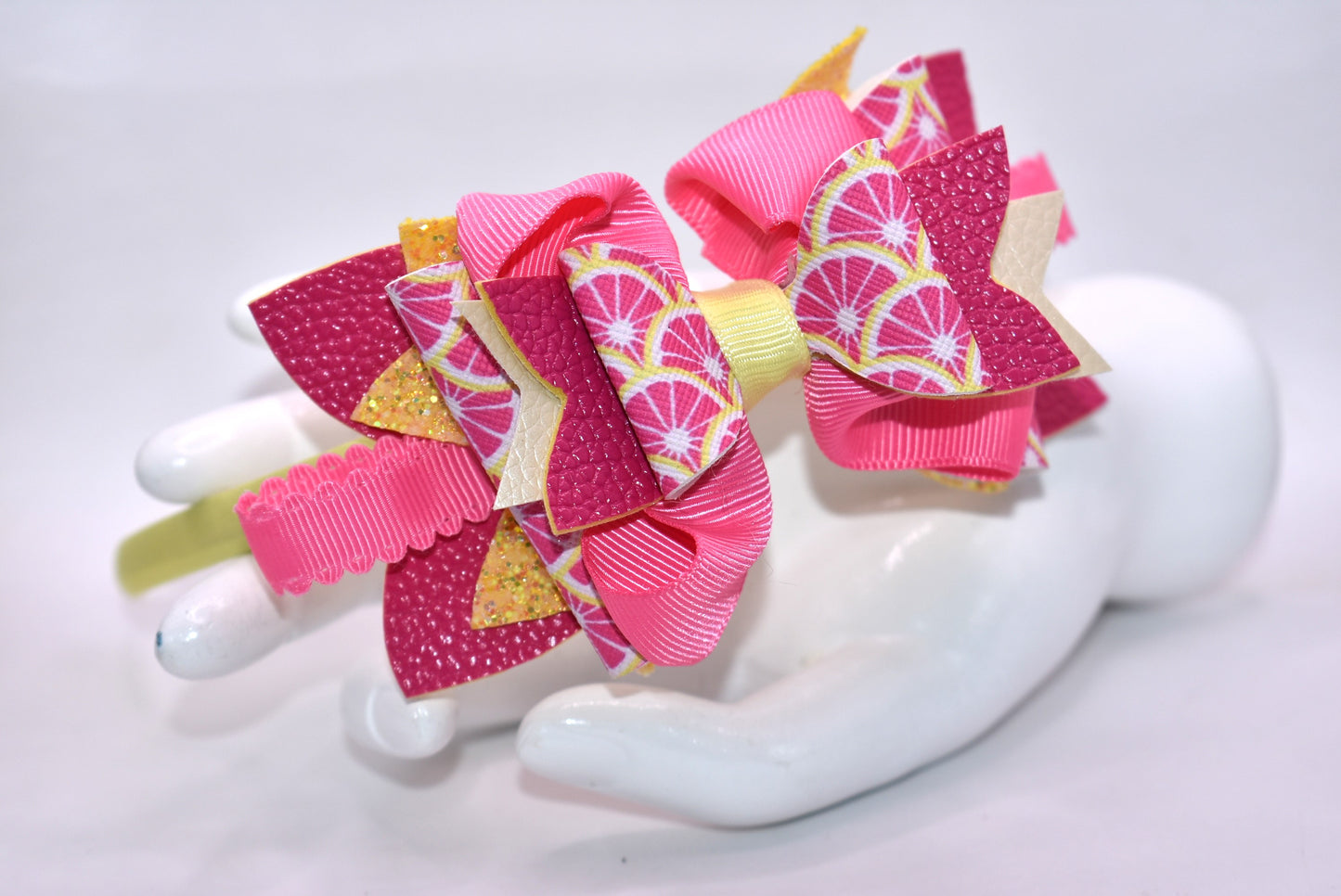 ✨ Introducing Nana's Headband Collection H2 – a one-of-a-kind accessory that's pure joy! 💕 This playful headband features luxurious layers of faux leather and grosgrain ribbon in gorgeous pink and yellow tones that'll brighten any day. The flexible yellow satin base ensures all-day comfort, while sparkling embellishments add that extra dash of fun and personality. 🎀 Whether you're dressing up or keeping it casual, this charming piece brings instant style and whimsy to your look. 🌟