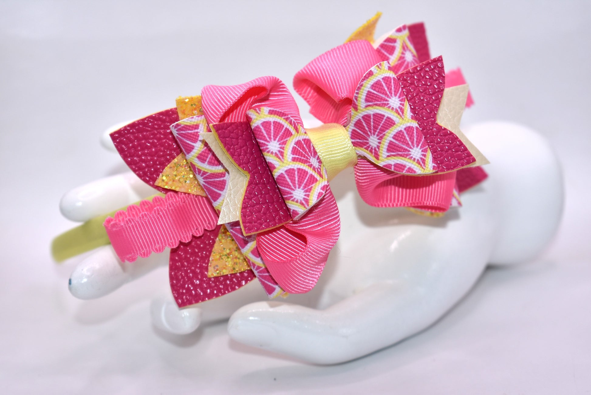 ✨ Introducing Nana's Headband Collection H2 – a one-of-a-kind accessory that's pure joy! 💕 This playful headband features luxurious layers of faux leather and grosgrain ribbon in gorgeous pink and yellow tones that'll brighten any day. The flexible yellow satin base ensures all-day comfort, while sparkling embellishments add that extra dash of fun and personality. 🎀 Whether you're dressing up or keeping it casual, this charming piece brings instant style and whimsy to your look. 🌟