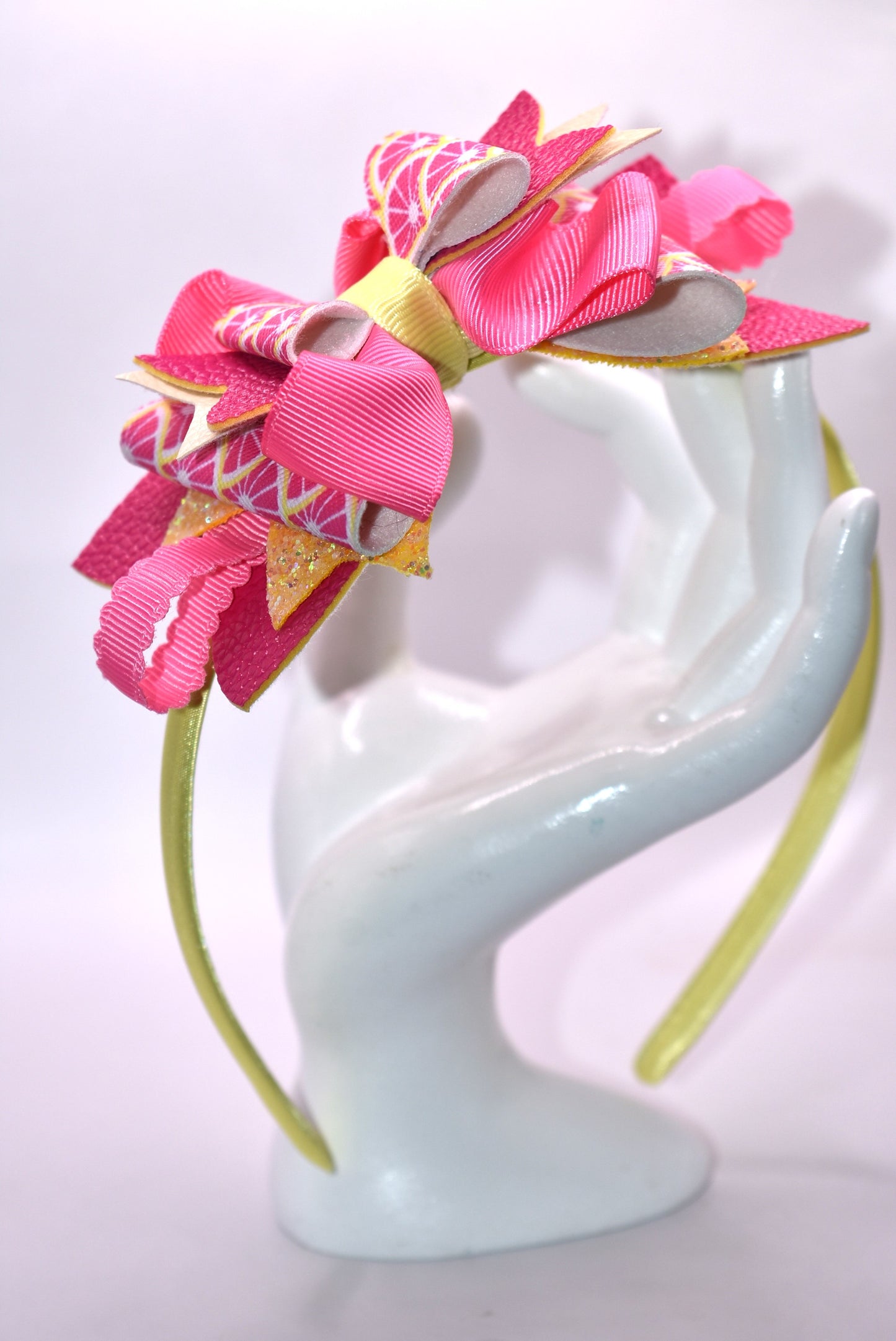 ✨ Introducing Nana's Headband Collection H2 – a one-of-a-kind accessory that's pure joy! 💕 This playful headband features luxurious layers of faux leather and grosgrain ribbon in gorgeous pink and yellow tones that'll brighten any day. The flexible yellow satin base ensures all-day comfort, while sparkling embellishments add that extra dash of fun and personality. 🎀 Whether you're dressing up or keeping it casual, this charming piece brings instant style and whimsy to your look. 🌟