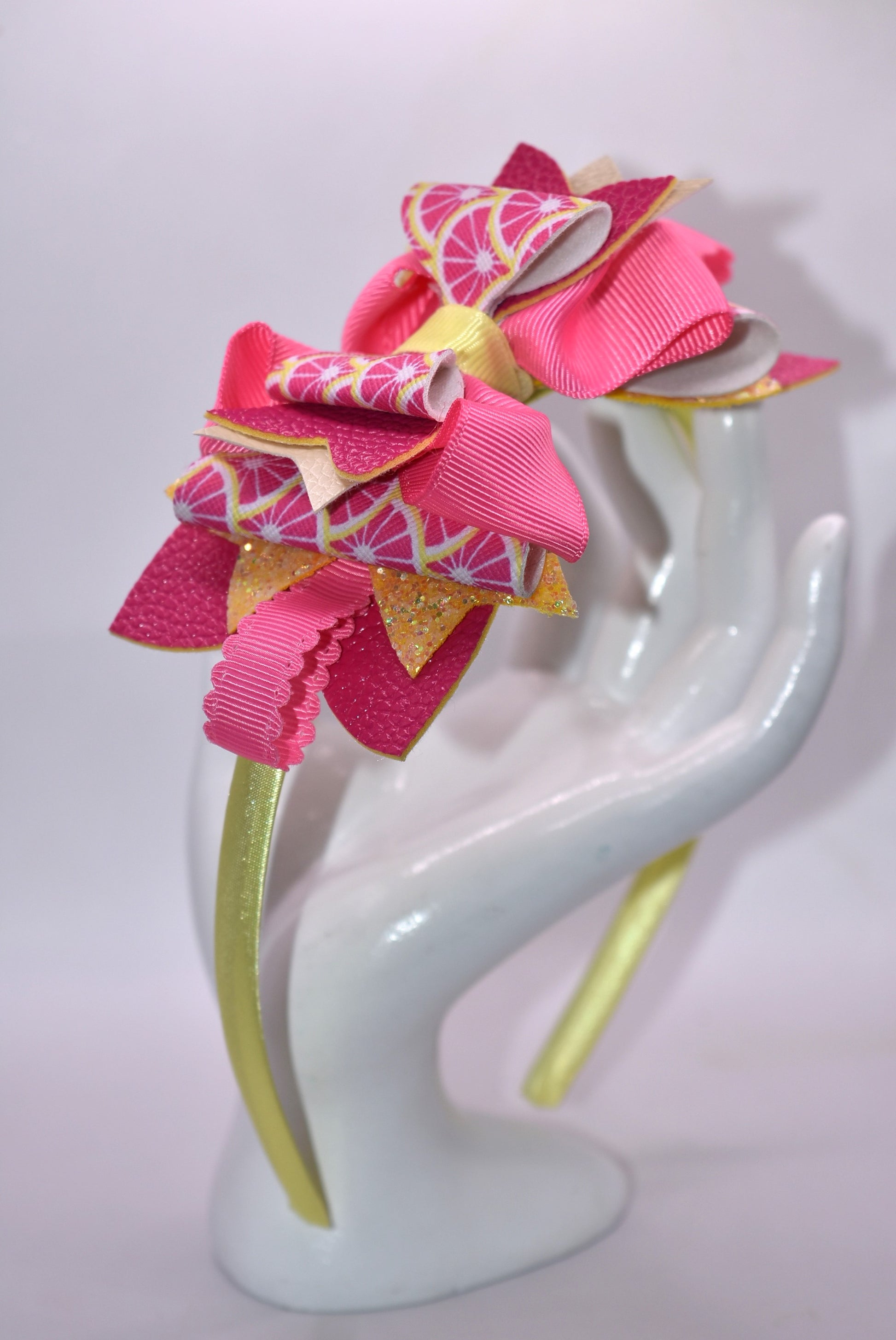 ✨ Introducing Nana's Headband Collection H2 – a one-of-a-kind accessory that's pure joy! 💕 This playful headband features luxurious layers of faux leather and grosgrain ribbon in gorgeous pink and yellow tones that'll brighten any day. The flexible yellow satin base ensures all-day comfort, while sparkling embellishments add that extra dash of fun and personality. 🎀 Whether you're dressing up or keeping it casual, this charming piece brings instant style and whimsy to your look. 🌟