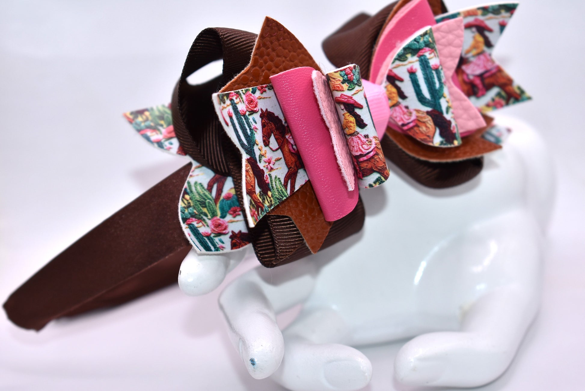 Saddle up, partner! 🤠 This one-of-a-kind headband brings serious cowgirl vibes with its charming faux leather and ribbon motif in gorgeous shades of brown and pink. 🌸 The wide silk construction keeps things comfy all day long, while the flexible design moves with you—no pinching, no fussing. Whether you're channeling your inner rodeo queen or just want to add some playful Western flair to your look, this beauty delivers style with zero compromise. 💕 Yeehaw!