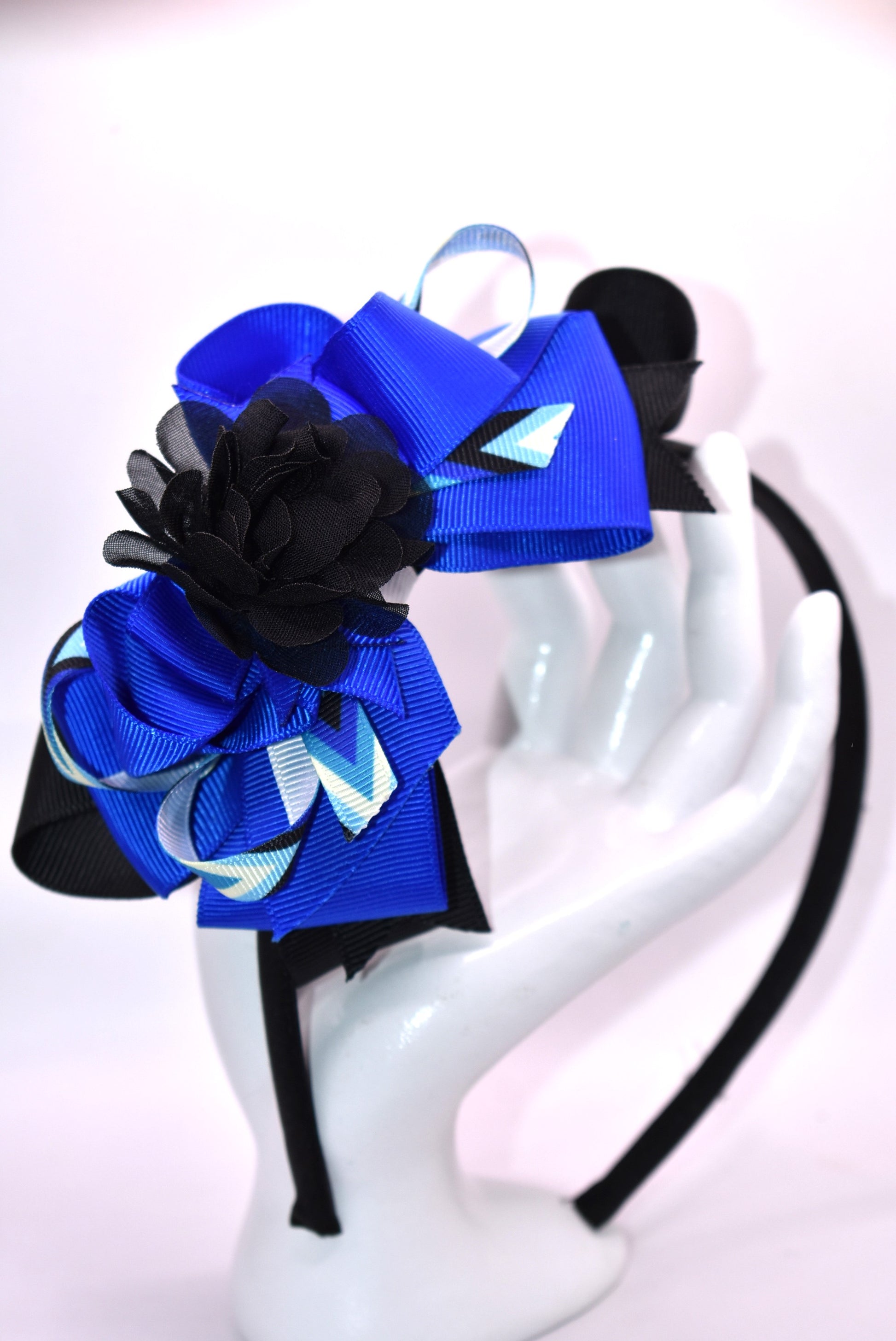 ✨ Elevate your look with this stunning blue and black headband from Nana's Collection! Crafted from silky satin for all-day comfort, this thin, lightweight design features beautifully layered ribbons that add dimension and style. Topped with an elegant black chiffon flower, it's the perfect finishing touch for any outfit—from casual days to special occasions. 🎀 Whether you're dressing up or keeping it simple, this headpiece brings that extra touch of pretty to your ensemble. 💙
