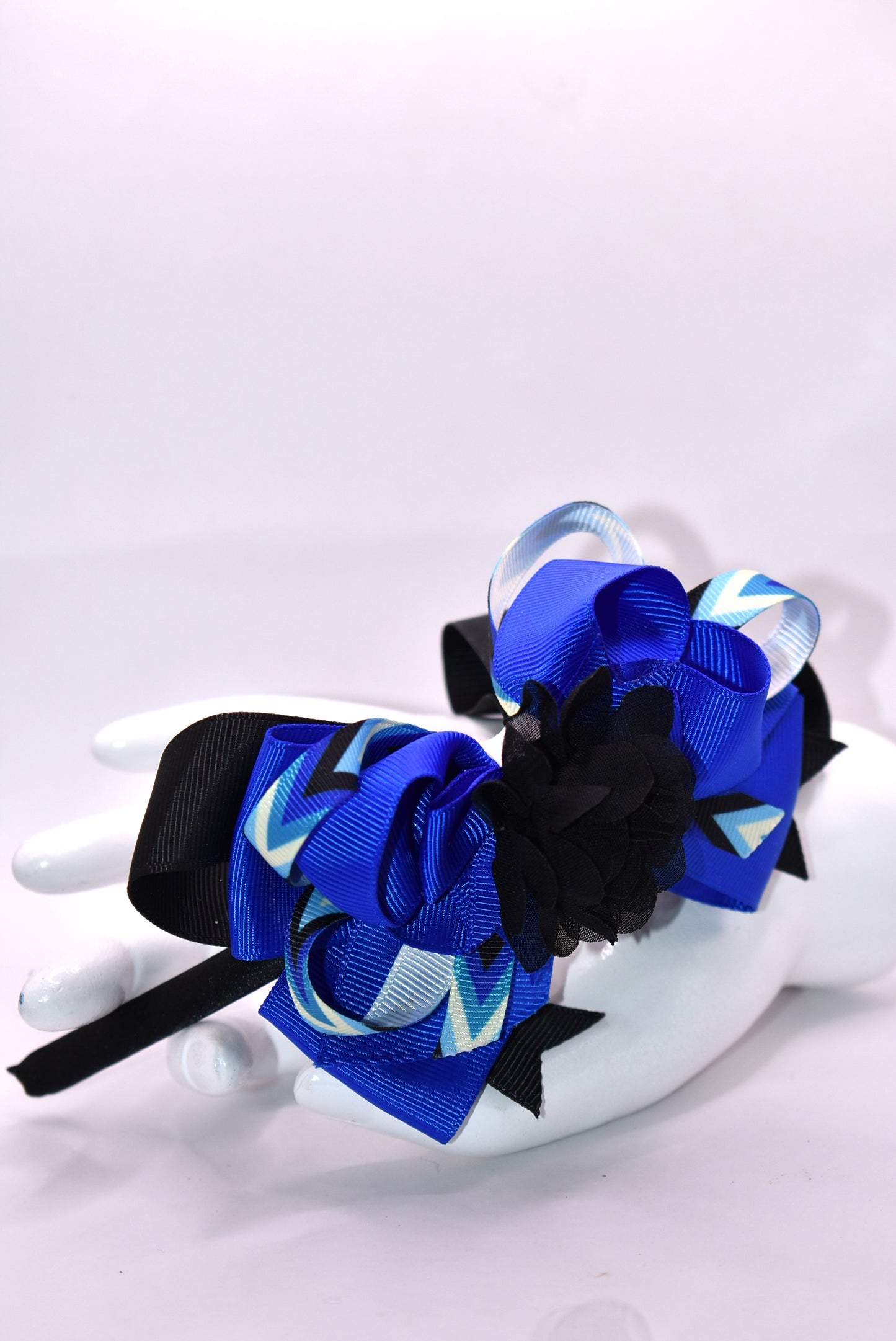 ✨ Elevate your look with this stunning blue and black headband from Nana's Collection! Crafted from silky satin for all-day comfort, this thin, lightweight design features beautifully layered ribbons that add dimension and style. Topped with an elegant black chiffon flower, it's the perfect finishing touch for any outfit—from casual days to special occasions. 🎀 Whether you're dressing up or keeping it simple, this headpiece brings that extra touch of pretty to your ensemble. 💙