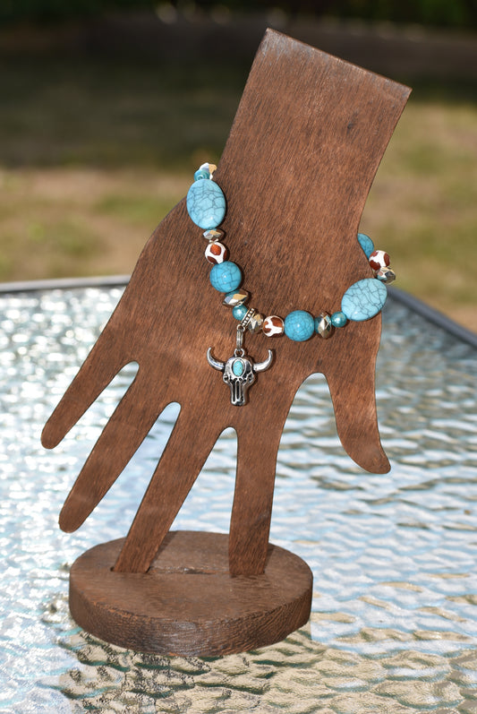 This Western Collection bracelet showcases classic cowgirl style with an elegant combination of turquoise and cow print beads, and a steer head charm hanging for a unique finish. It's comfortable too, with a stretchy band that will fit any wrist size. Get the perfect combination of fashion and comfort with the Western Collection bracelet.