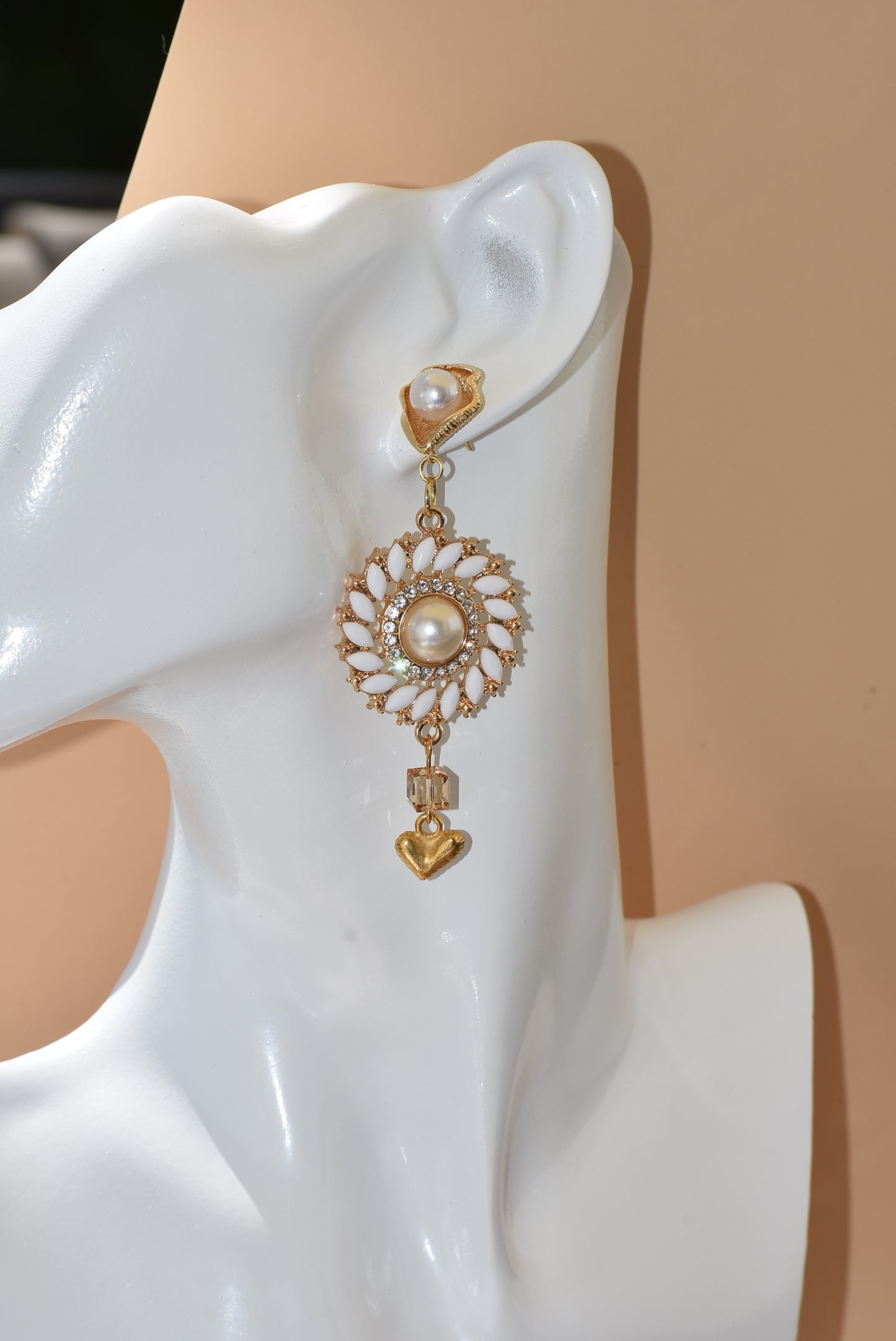 Our Wedding Collection 18 earrings feature bold gold colors and an unusual pearl post, bordered with white marquise beading and white crystals. A small gold heart hangs from the bottom, making a huge statement on the ear. Perfect for any special occasion.