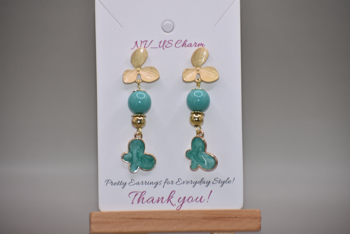 The Green Collection 23 earrings are the perfect addition to any outfit. These elegant earrings feature brushed gold flower posts with pretty jade beading and gold accents. A stunning green charm hangs from the posts, completing the look.