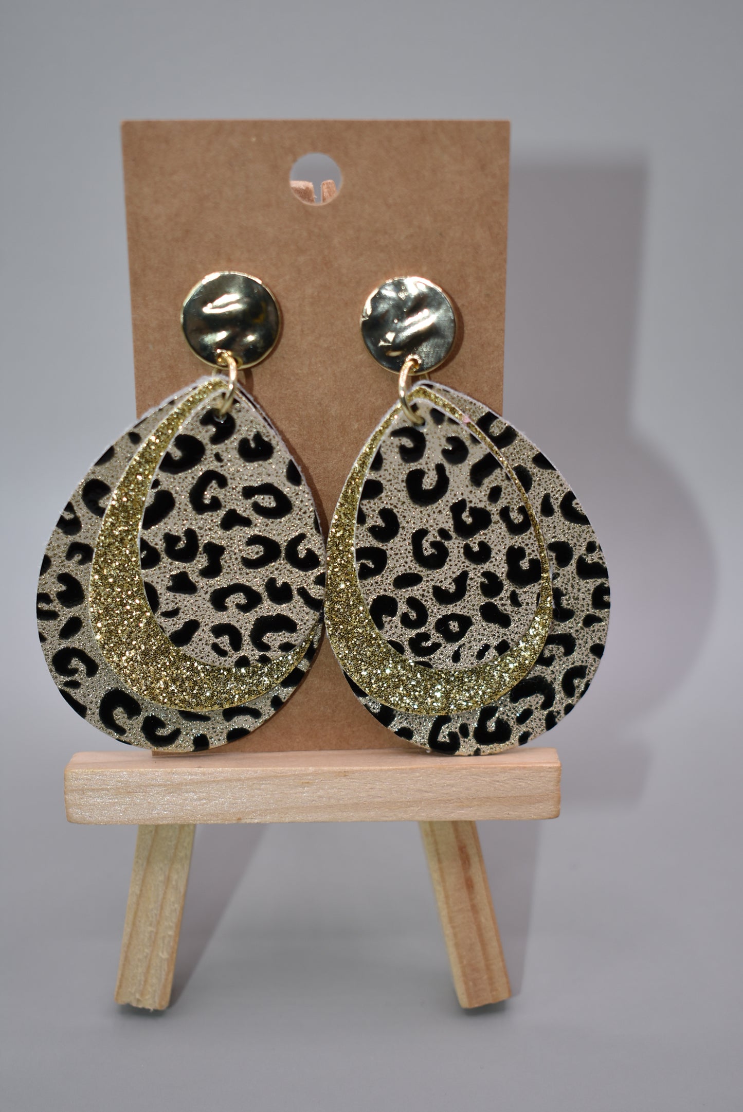 ﻿These gold stunners are sure to get attention.  Gold posts and gold glitter and leopard print teardrops bring these earrings to life.  You will be roaring in these.  