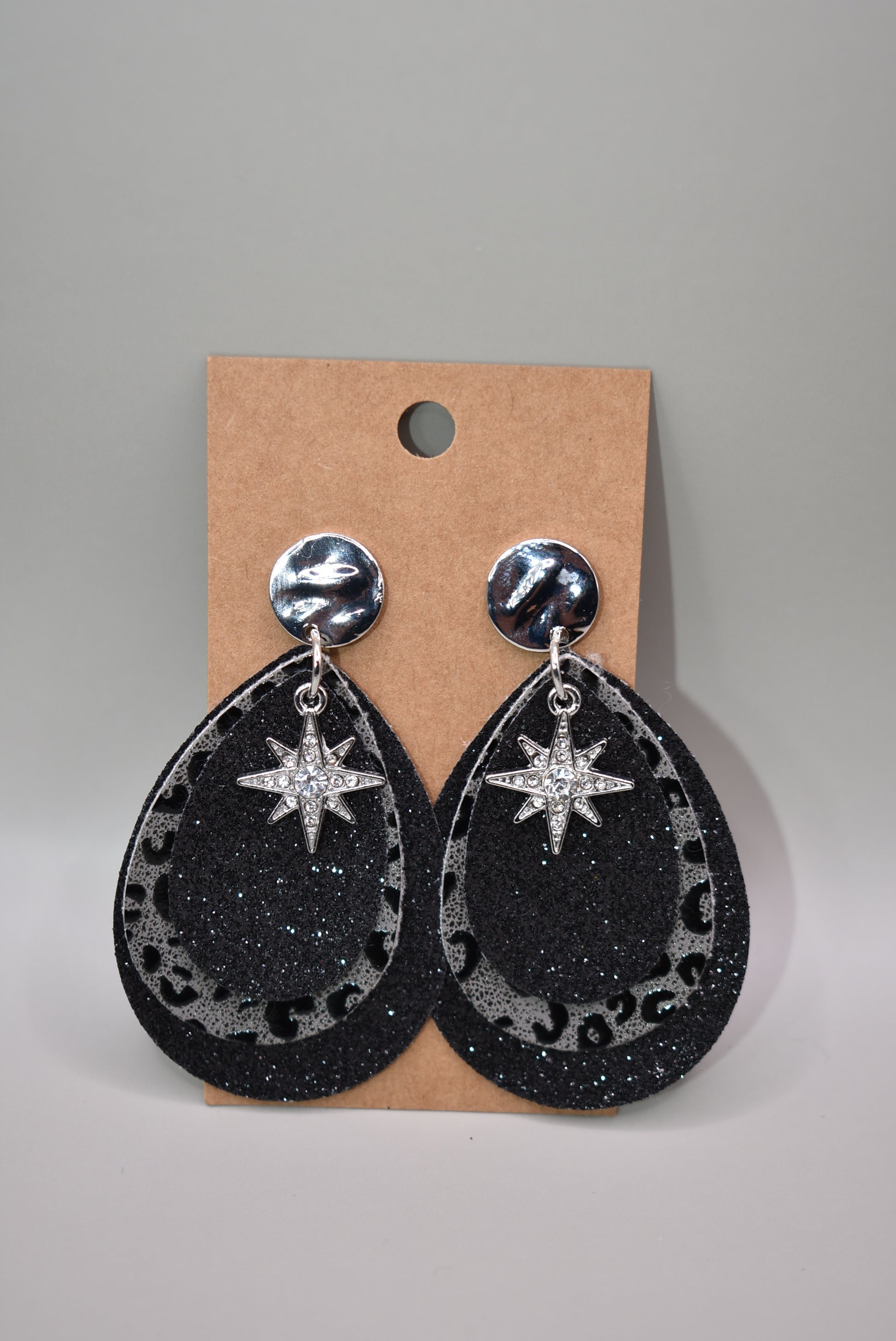 ﻿Black glitter teardrops hold a center leopard print in black and gray.  A pretty crystal star charm hangs from the top of these silver post earrings.  