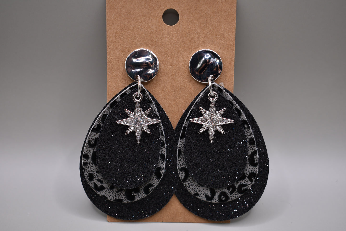 Black glitter teardrops hold a center leopard print in black and gray.  A pretty crystal star charm hangs from the top of these silver post earrings.  