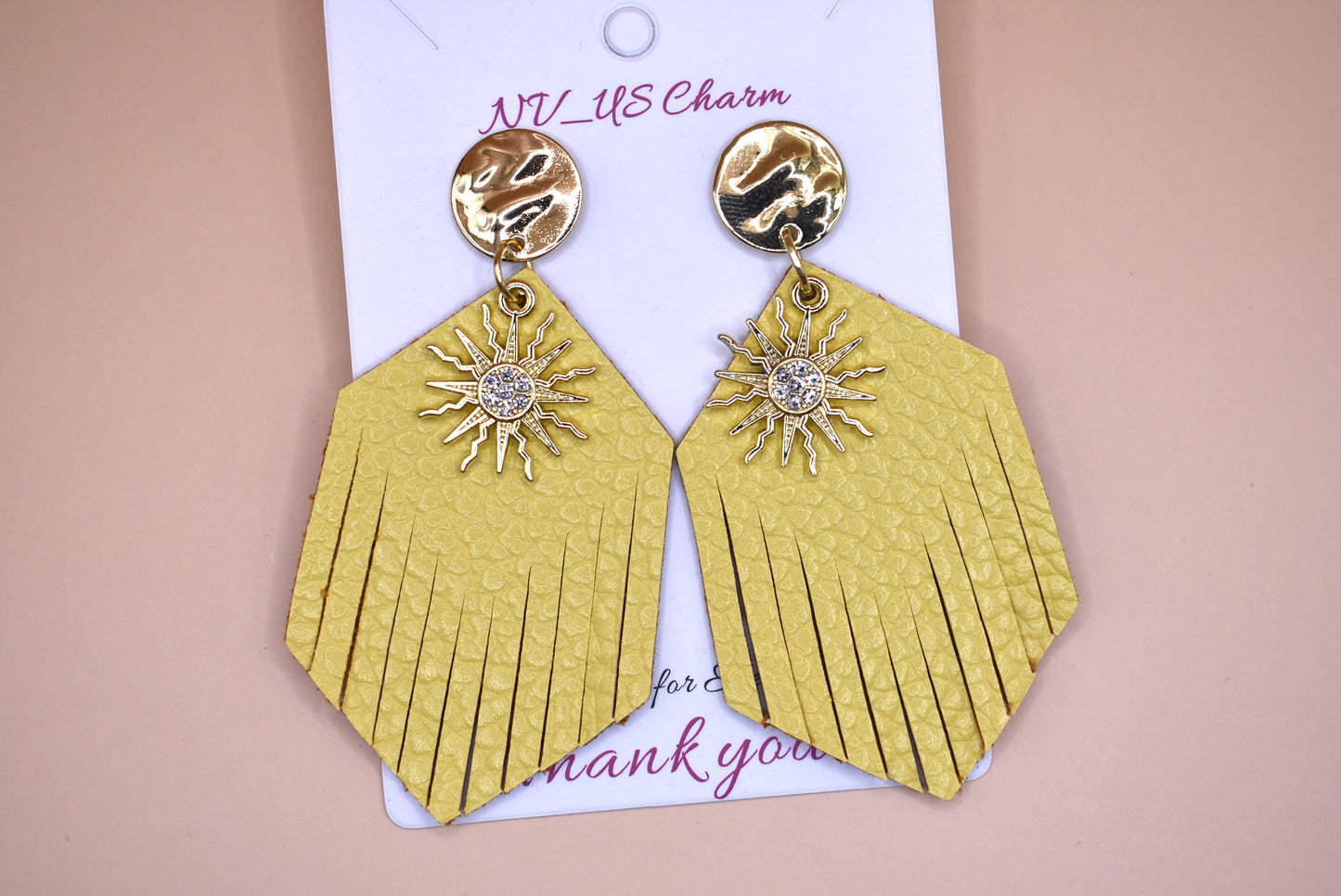 These gold faux leather teardrop fringed earrings have a perfect shiny sun charm with crystal in the center to brighten up your day and definitely your wardrobe.  Super comfortable hanging on gold posts.  