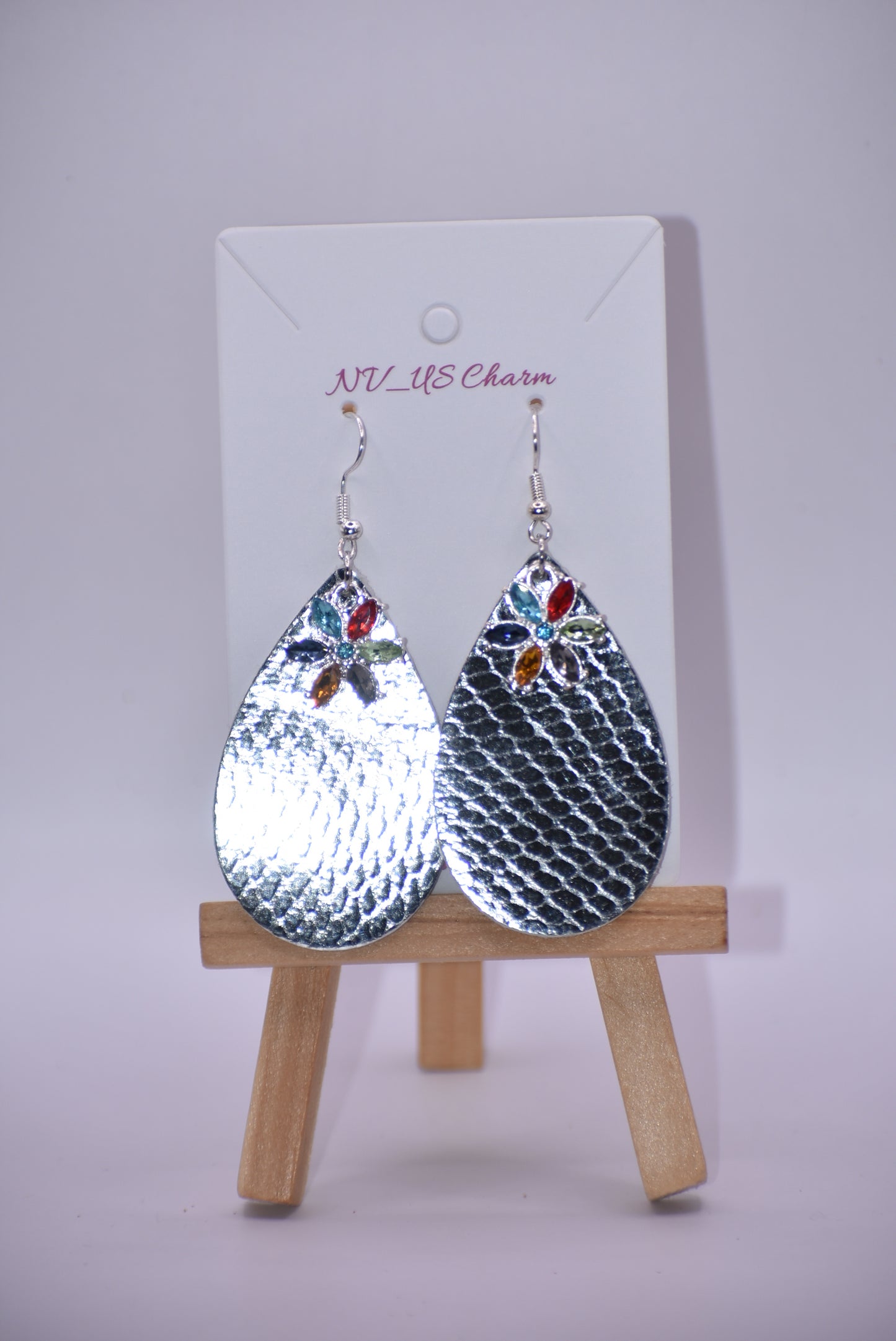 These pretty silver metallic teardrop earrings have a colored crystal flower hanging down and are on silver hooks.  Super comfortable.  Goes with everything.  