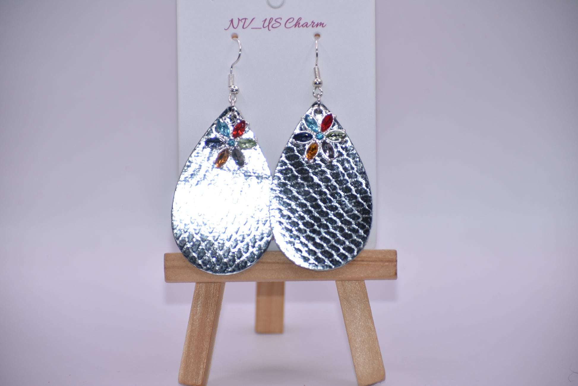 These pretty silver metallic teardrop earrings have a colored crystal flower hanging down and are on silver hooks.  Super comfortable.  Goes with everything.  