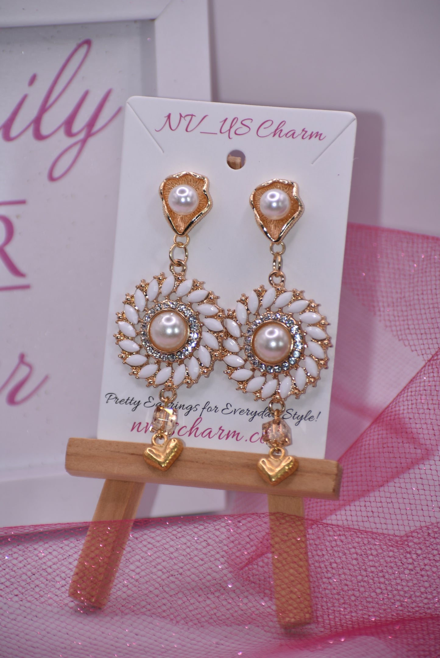 Our Wedding Collection 18 earrings feature bold gold colors and an unusual pearl post, bordered with white marquise beading and white crystals. A small gold heart hangs from the bottom, making a huge statement on the ear. Perfect for any special occasion.